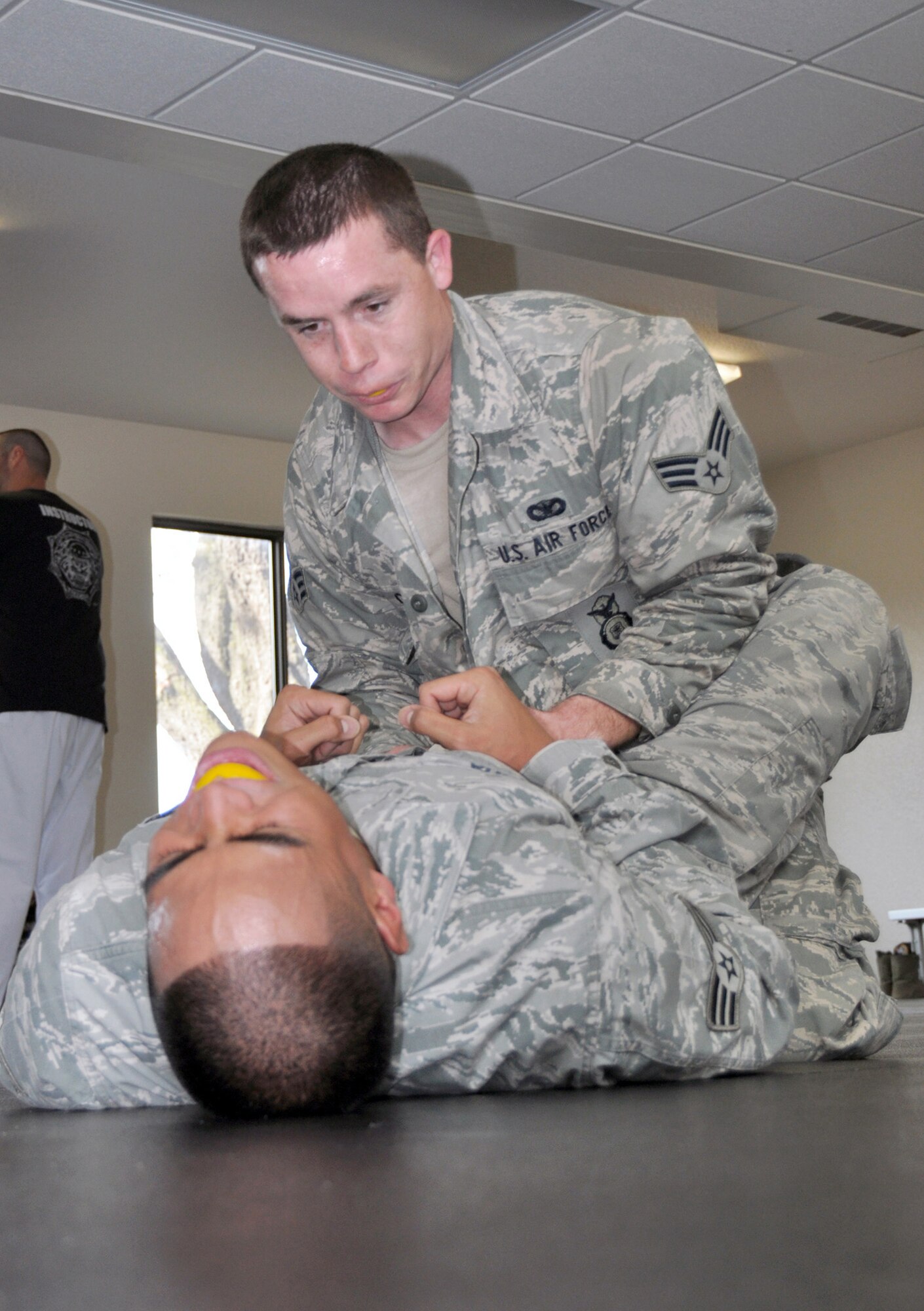 TRAVIS AIR FORCE BASE, Calif. -- Senior Airman Alex Bombita, 349th Security Forces Squadron, officer, tries to dismount Senior Airman Lucas Gibson, 349th SFS, officer, as they practice defensive combative moves on Jan. 4, 2014. The training teaches security forces personnel defensive moves to help create space between officers and suspects, providing opportunities for officers to access other means of force. (U.S. Air Force photo/Senior Airman Cindy G. Alejandrez)