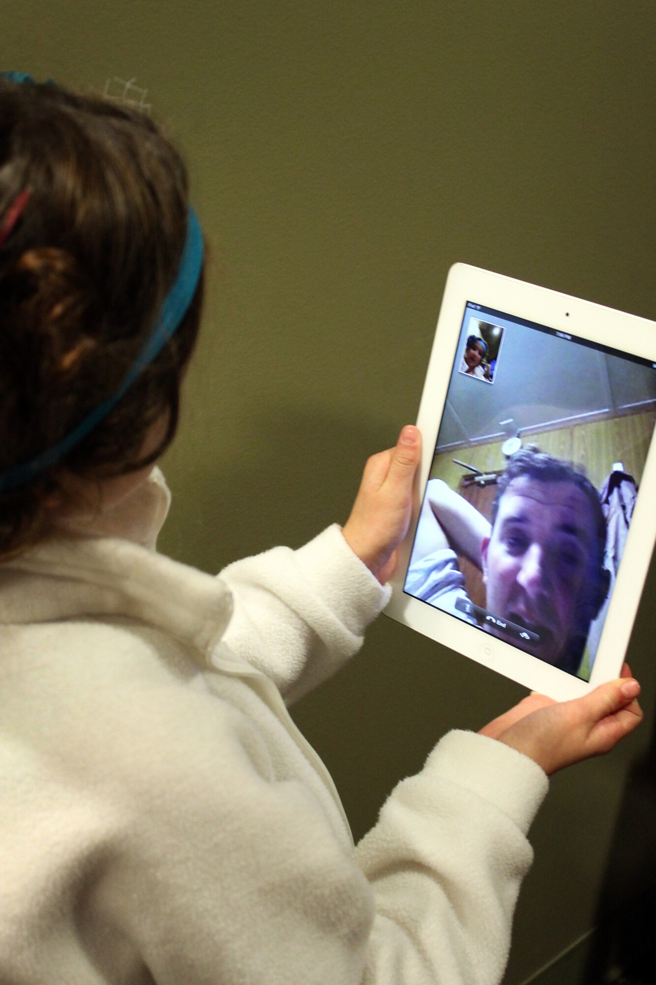 Master Sgt. Michael Morgan, 72nd Air Refueling Squadron inflight refueling evaluator, congratulates his daughter, Melea, on a tablet device after watching her play violin during a recital in Indianapolis Oct. 27, 2013. Morgan kept in close contact with his family during a recent deployment to Southwest Asia. (U.S. Air Force photo/Tech. Sgt. Erica Morgan)