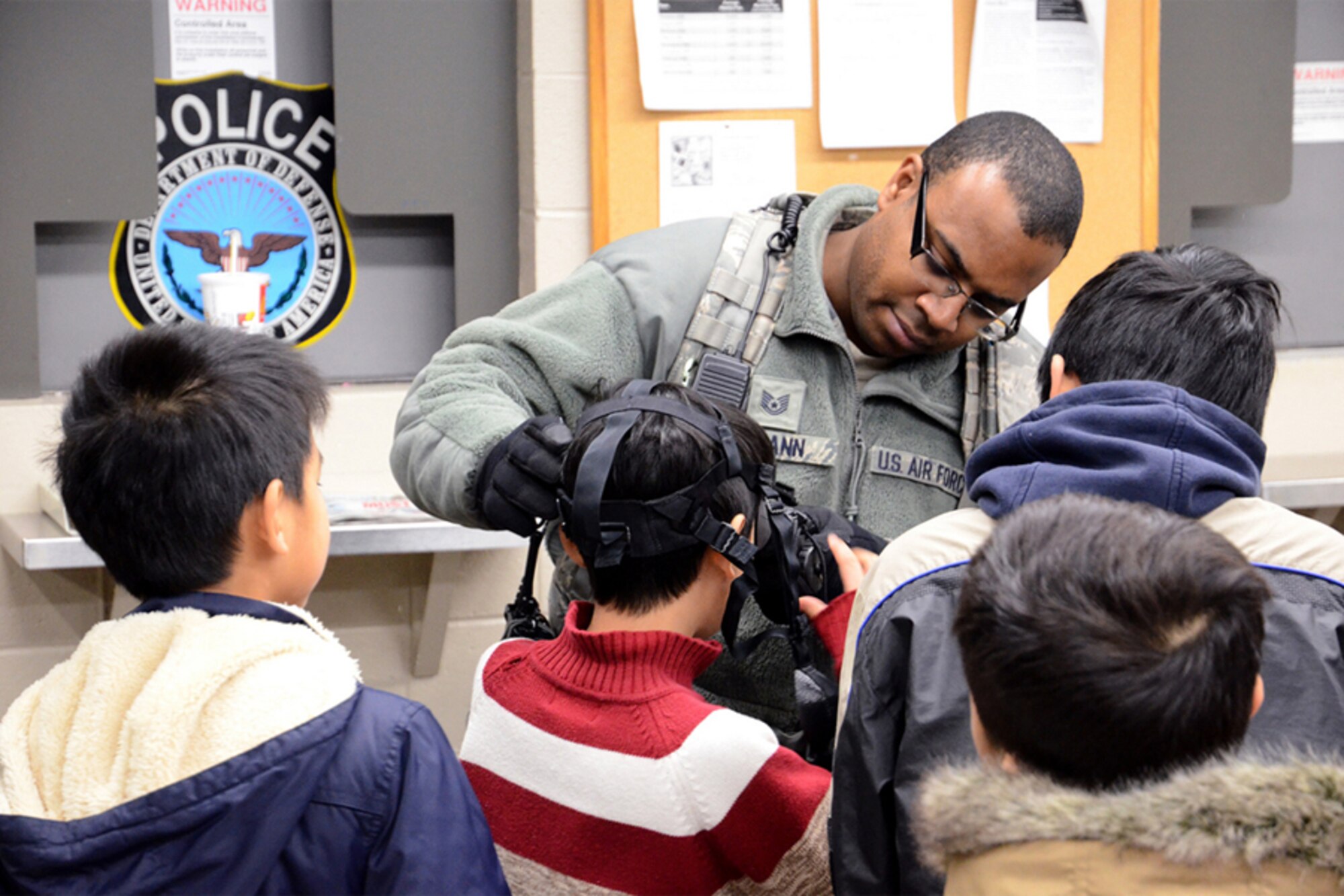 Tech. Sgt. Julian Swann of the 94th Security Forces Squadron demonstrates the application of night-vision goggles to the North Atlanta Chinese Baptist Church students during a base tour Jan. 6. (U.S. Air Force photo/Brad Fallin)