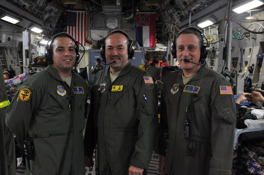 Staff Sgt. Gabriel Hannen, 349th Aeromedical Staging Squadron cardiopulmonary technician, Lt. Col. Duane Meller, 180th Medical Group Critical Care Transport nurse, and Lt. Col. Richard Lorriane 111th Medical Group internist, take a team photo during a medical ecacuation flight over the Atlantic en route to Andrews Air Force Base. The critical care transport team plays a key role in the aeromedical evacuation of patients and they would like to wish all of their family and friends a happy holidays.(U.S. Air Force photo/ Staff Sgt. Christopher Carranza)