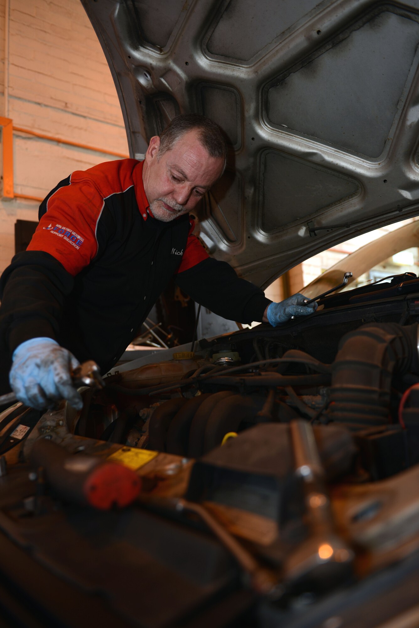 Nick Turmaine, 100th Force Support Squadron Auto Hobby Complex mechanic from London, finishes maintenance on a vehicle Jan. 8, 2014, in the Auto Hobby Complex on RAF Mildenhall, England. The complex offers space and equipment for U.S. military ID card holders and their dependents to perform do-it-yourself repairs and maintenance. Additionally, the complex provides mechanic and towing services by appointment. (U.S. Air Force photo by Airman 1st Class Preston Webb/Released)