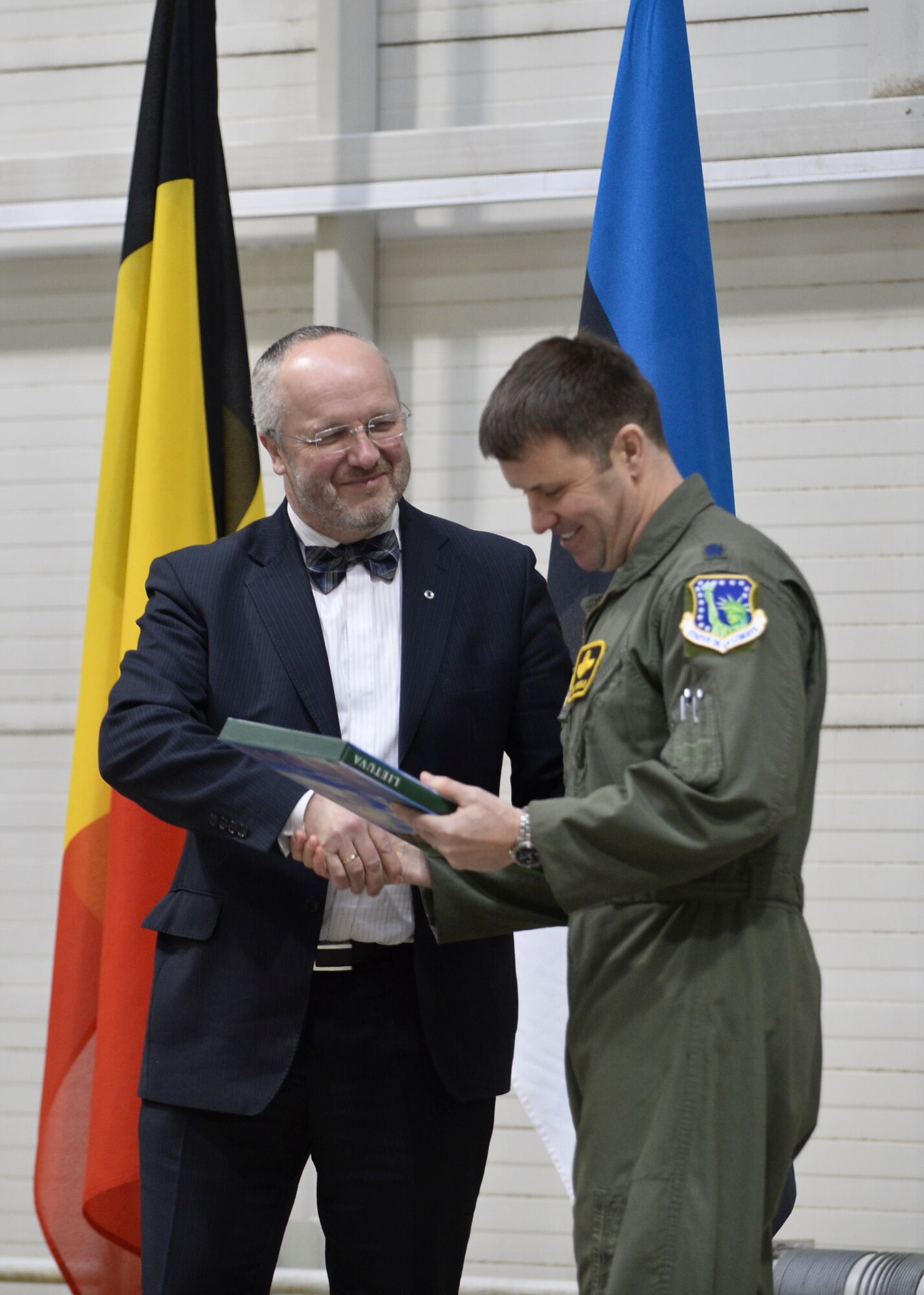 Minister of National Defence Juozas Olekas presents a book about Lithuania to Lt. Col. Lendy Renegar, 48th Air Expeditionary Group commander, during a change of command at Šiauliai Air Base, Lithuania, Jan. 3, 2014. The ceremony acknowledged the transfer of the Baltic Air Policing mission from the Belgian air force to the U.S. Air Force. The U.S. will maintain Lithuania’s sovereign air space for four months. (U.S. Air Force photo by Airman 1st Class Nigel Sandridge/Released)