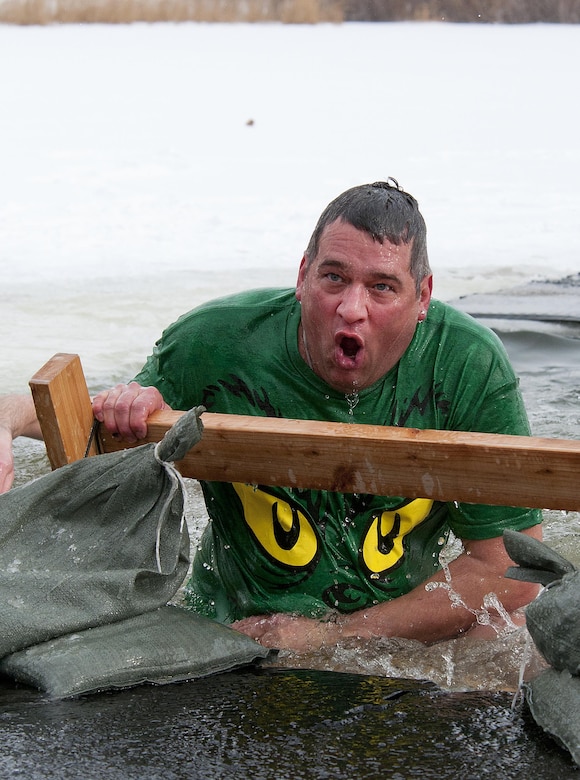 Gene Duran, 90th Civil Engineer Squadron unit deployment manager, scrambles to get out of the icy waters of Sloan Lake, Cheyenne, Wyo. during the second annual Matthew S. Schwartz Memorial Polar Plunge Jan. 4, 2013. Participants braved 16-degree air, and 30-degree water, temperatures to raise money for a foundation which helps wounded explosive ordnance technicians and their families. The event is named for an EOD technician with the 90th CES on F.E. Warren AFB who was killed in action while deployed to Afghanistan, Jan. 5, 2012. (U.S. Air Force photo by R.J. Oriez)