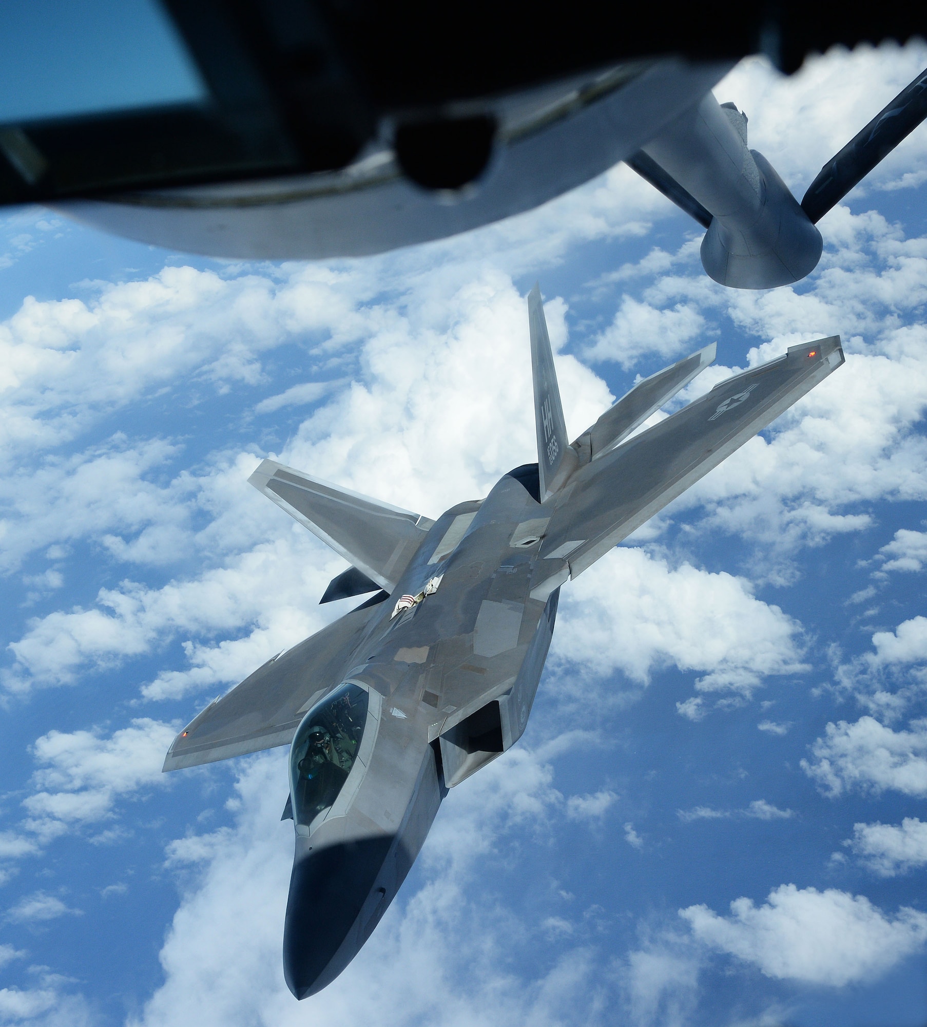 An F-22 Raptor from the 199th Fighter Squadron positions itself while preparing to receive fuel from a KC-135 Stratotanker from the 96th Air Refueling Squadron near Joint Base Pearl Harbor-Hickam, Hawaii, Jan. 10, 2014. Both aircrafts and their crew were participants in the Inaugural Total Force Integration Warrior Day, a training event that tested the cooperation and capabilities of multiple base agencies. The training highlighted the importance of integrating operations of active duty, Hawaii National Guard and Air Force Reserve units. (U.S. Air Force photo/Staff Sgt. Alexander Martinez)