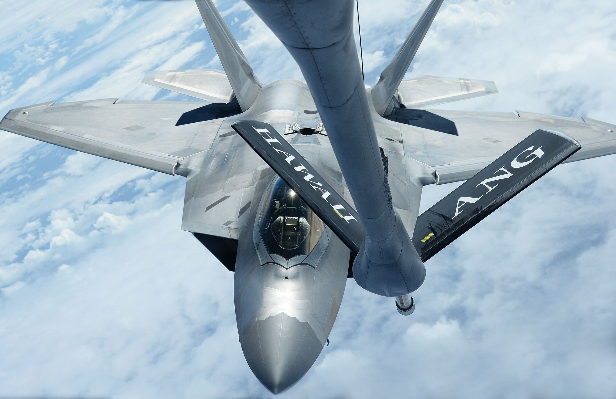 An F-22 Raptor from the 199th Fighter Squadron positions itself while preparing to receive fuel from a KC-135 Stratotanker from the 96th Air Refueling Squadron near Joint Base Pearl Harbor-Hickam, Hawaii, Jan. 10, 2014. Both aircrafts and their crew were participants in the Inaugural Total Force Integration Warrior Day, a training event that tested the cooperation and capabilities of multiple base agencies. The training highlighted the importance of integrating operations of active duty, Hawaii National Guard and Air Force Reserve units. (U.S. Air Force photo/Staff Sgt. Alexander Martinez)