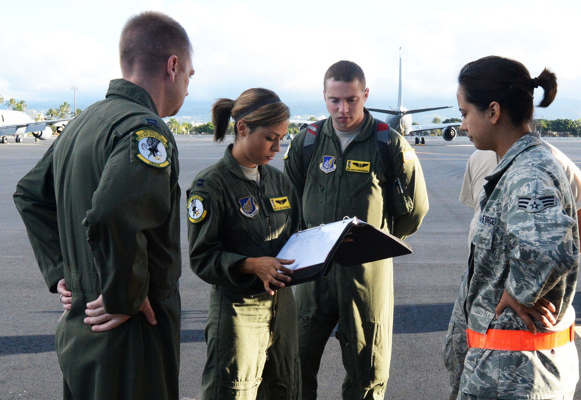 Capt. Nikita Wetherbee, 96th Air Refueling Squadron, goes over checklist items with air and ground crew before boarding a KC-135 Stratotanker at Joint Base Pearl Harbor-Hickam, Hawaii, Jan. 10, 2014. Wetherbee, a KC-135 pilot, and her crew were participants in the Inaugural Total Force Integration Warrior Day, a training event that tested the cooperation and capabilities of multiple base agencies. The training highlighted the importance of integrating operations of active duty, Hawaii National Guard and Air Force Reserve units. (U.S. Air Force photo/Staff Sgt. Alexander Martinez)