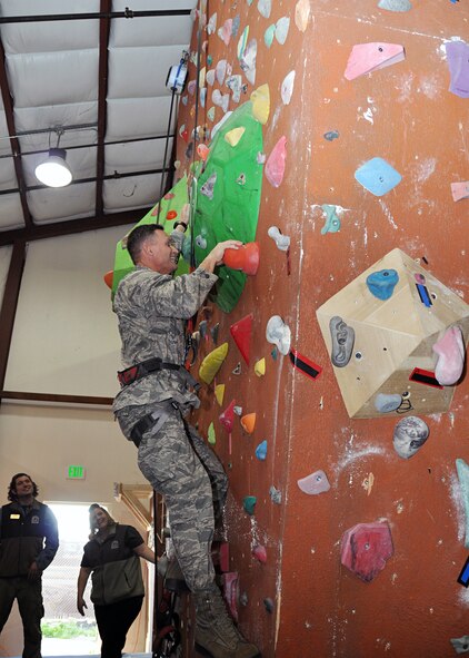 Col. Brett Clark, 94th Airlift Wing commander at Dobbins Air Reserve Base, Ga. and one of the Commander in Chief Installation Excellence Award inspectors, climbs the Outdoor Recreation’s new rock wall Tuesday as members from the 60th Force Support Squadron look on. (Air Force photo/Senior Airman Cindy Alejandrez)