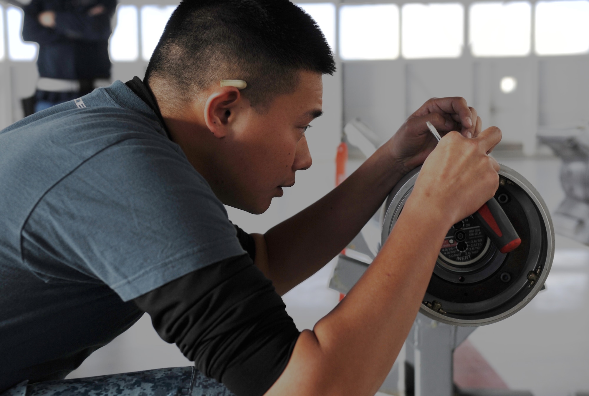 Republic of Singapore ME1 Ian Koh, 428th Fighter Squadron flightline crew member, inspects a training munition during pre-checks at Mountain Home Air Force Base, Idaho, Jan. 7, 2013. Koh was one of three 428th FS members chosen to participate in the annual Load Crew of the Year Competition due to his performance throughout 2013. (U.S Air Force photo by Airman 1st Class Brittany A. Chase/Released)