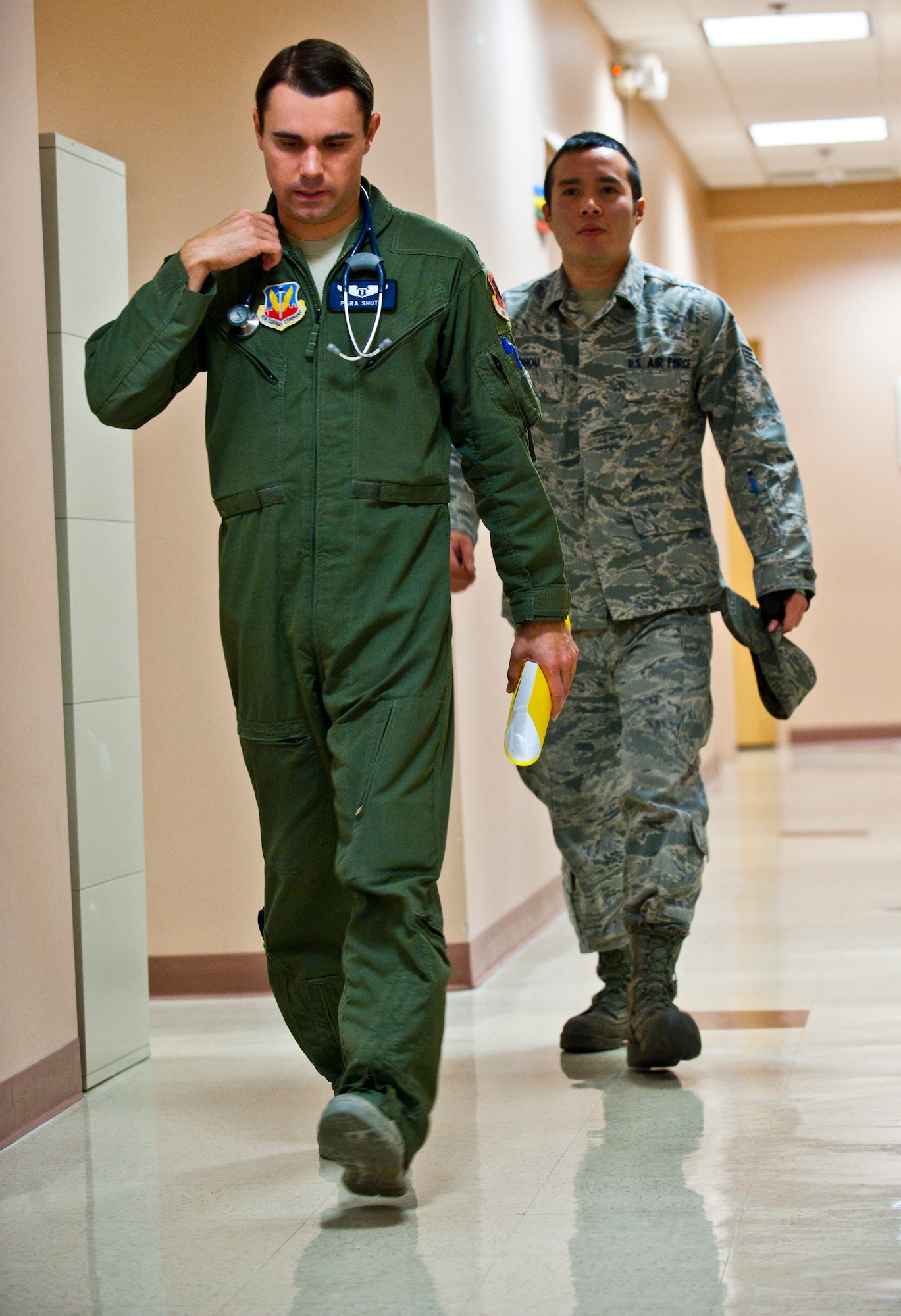 U.S. Air Force Capt. (Dr.) Thomas Shute, 42nd Attack Squadron flight surgeon, walks with his patient, Senior Airman Phou Johnson, 757th Aircraft Maintenance Squadron avionics technician, during an occupational health exam Jan. 10, 2014, at Nellis Air Force Base, Nev. Occupational health exams help flight surgeons have a better understanding of what aircrew members endure in the environments they work in. (U.S. Air Force photo/Senior Airman Brett Clashman)