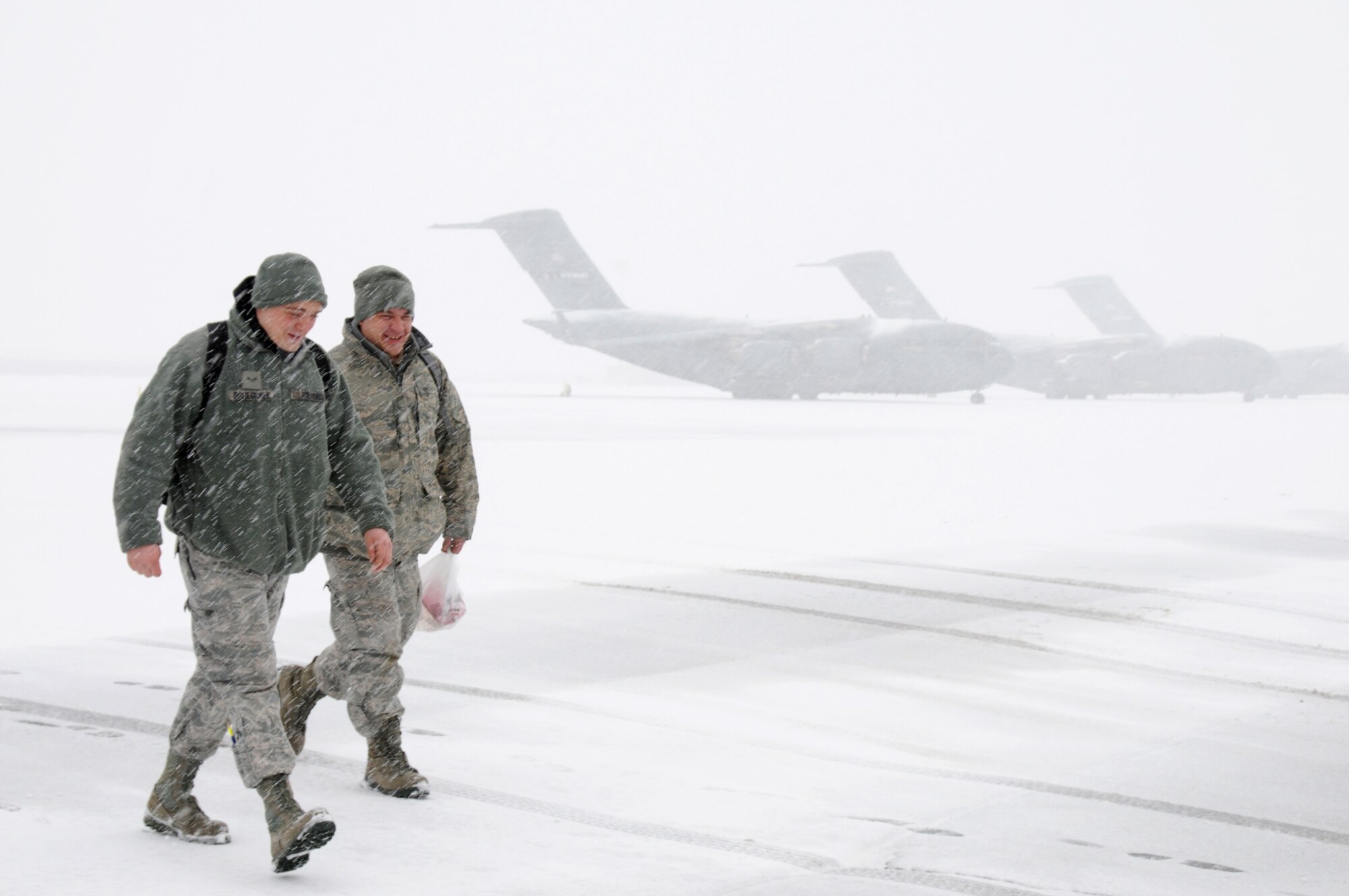 U.S. airmen with the 105th Airlift Wing, New York Air National Guard walk across the ramp at Stewart Air National Guard Base, N.Y., during a winter storm. (U.S. Air Force photo by Tech. Sgt. Michael O'Halloran/Released)


