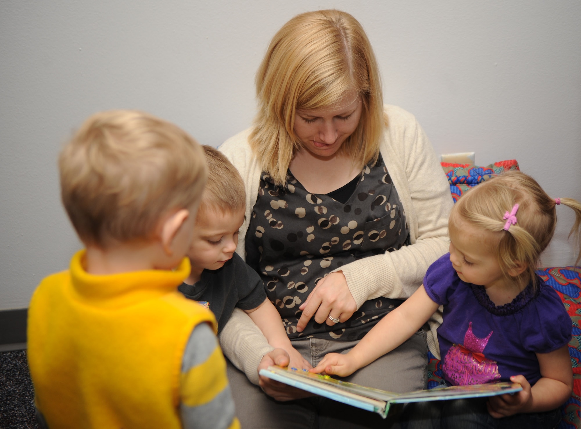 Sarah Snyder, MOPS volunteer, reads to the children, Moppettes, during the religious education program at Davis-Monthan Air Force Base, Ariz., Jan 10, 2014. MOPS is a program that meets twice a month for mothers to bond and for children to receive religious education. (U.S. Air Force photo by Senior Airman Camilla Elizeu/ Released)