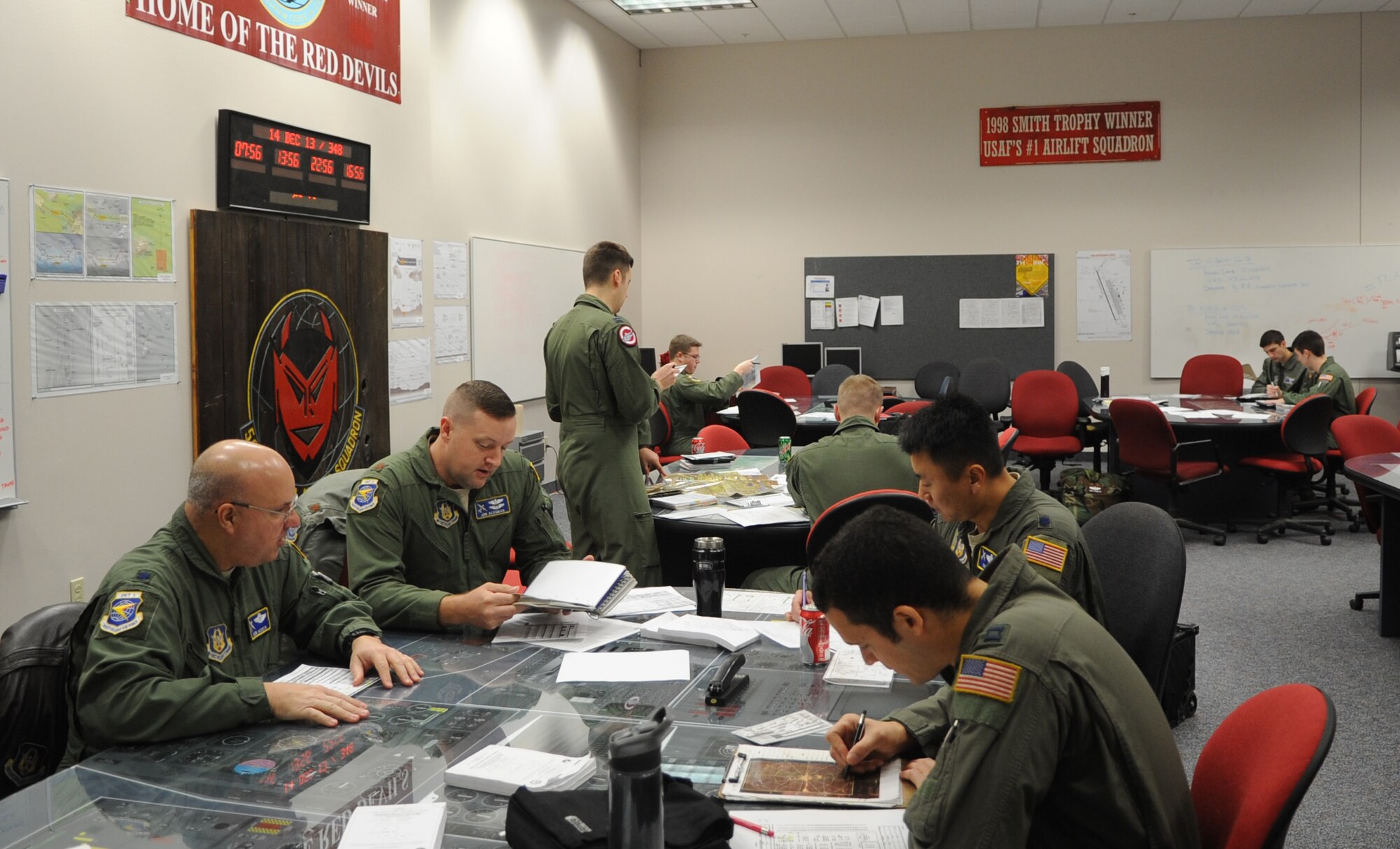Members of the 50th Airlift Squadron and the 22nd Air Force Det. 1, review their flight plans for the mission Dec. 14, 2013, at Little Rock Air Force Base, Ark.  The mission encompassed flight planning, flight brief, the flight and a debrief. (U.S. Air Force photo by Staff Sgt. Caleb Pierce)