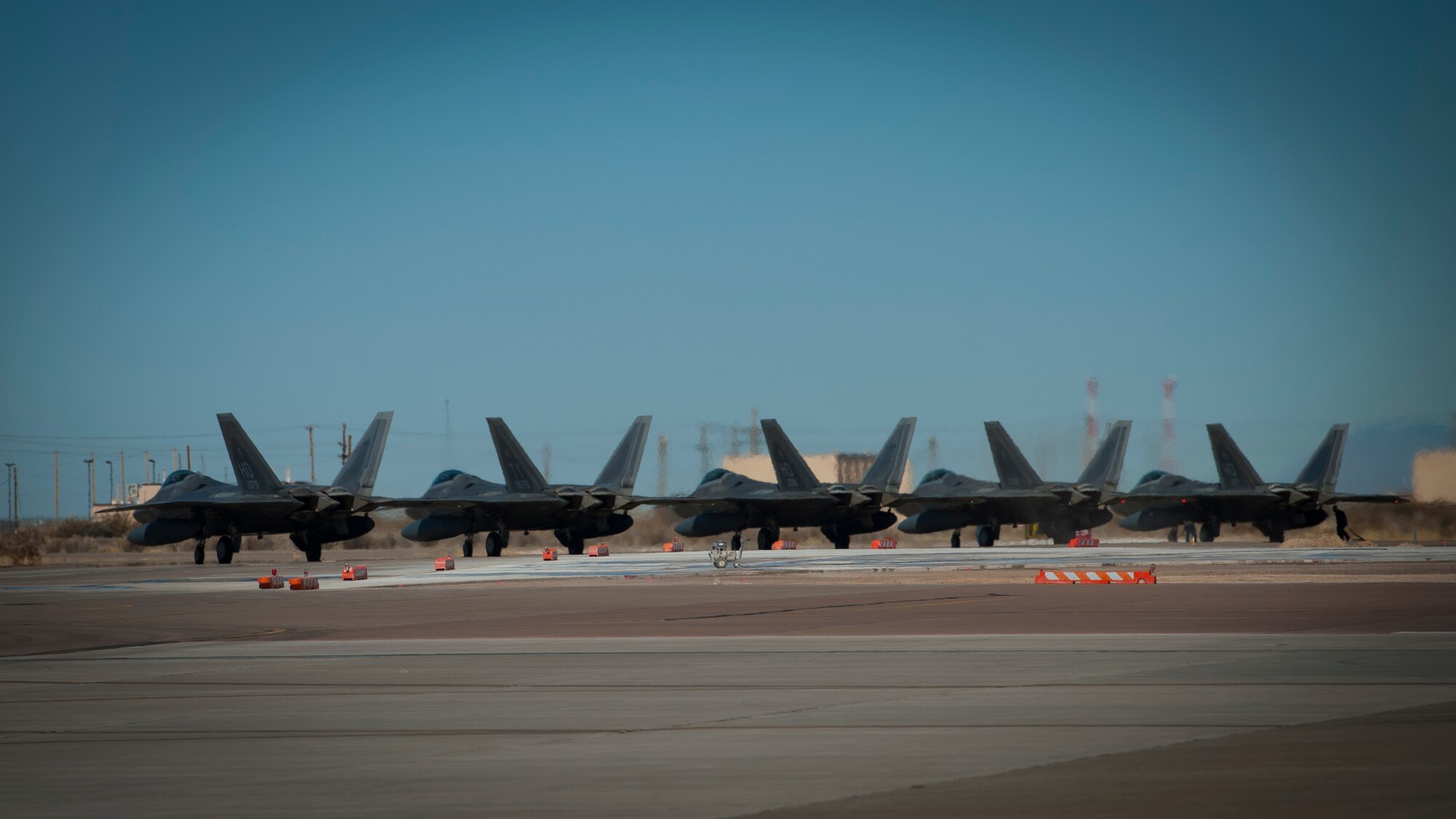 F-22 Raptors line up before taxiing down the runway at Holloman Air Force Base, N.M., Jan. 6. The first five of 24 combat-deployable F-22 Raptors left Holloman heading to Tyndall Air Force Base, Fla. as a permanent change of station. The five F-22s that left Jan. 6 will be followed by six Raptors leaving each month until the move is completed. (U.S. Air Force photo by Airman 1st Class Aaron Montoya)