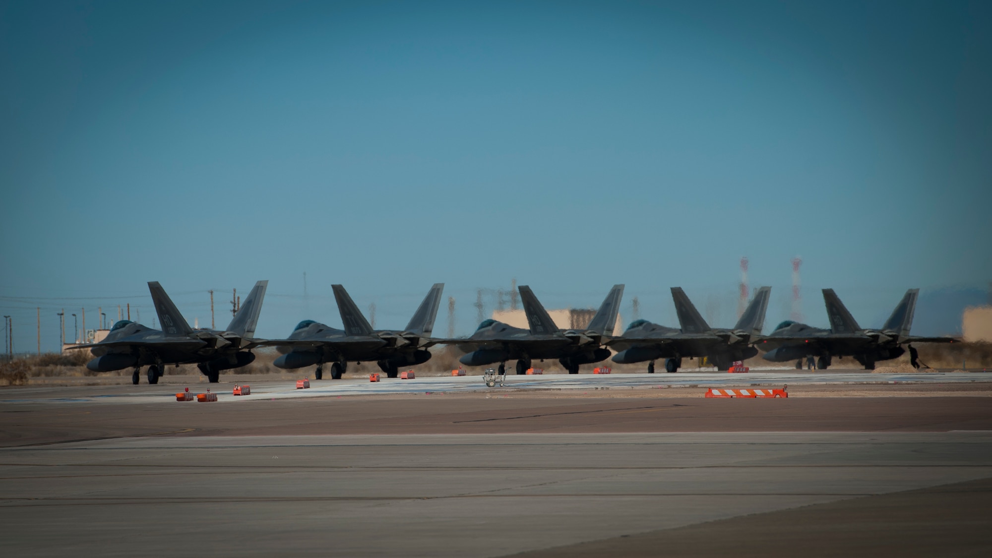 F-22 Raptors line up before taxiing down the runway at Holloman Air Force Base, N.M., Jan. 6. The first five of 24 combat-deployable F-22 Raptors left Holloman heading to Tyndall Air Force Base, Fla. as a permanent change of station. The five F-22s that left Jan. 6 will be followed by six Raptors leaving each month until the move is completed. (U.S. Air Force photo by Airman 1st Class Aaron Montoya)