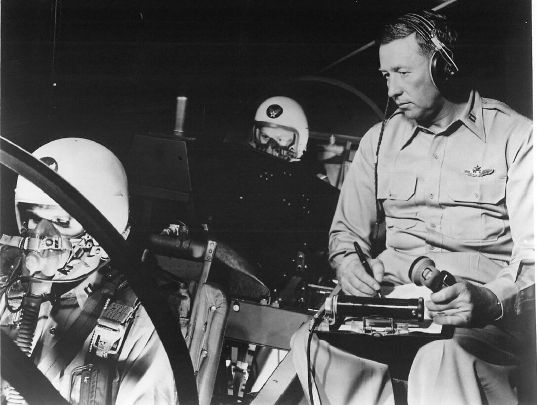 FLYING THE CHAIR OF A B-47 SIMULATOR. This Captain at March Air Force Base checks on two pilots flying a simulated mission in Southern California. Sometimes during the mission pilots are asked to "bail out" when their B-47 is in trouble. (Strategic Air Command Archives)