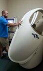 Jonathan Low, Hickam Human Performance and Rehabilitation Center exercise physiologist and personal trainer, explains the process for taking a body fat measurement using the Bod Pod to a patient at the HPARC on Joint Base Pearl Harbor-Hickam, Hawaii, Jan. 9, 2014. The Bod Pod is one of the tools used by the HPARC staff to track the progress of fitness class participants over periods of  time. The Bod Pod tracks and measures body fat and lean muscle mass by using air displacement technology. (U.S. Air Force photo/Tech. Sgt. Terri Paden)