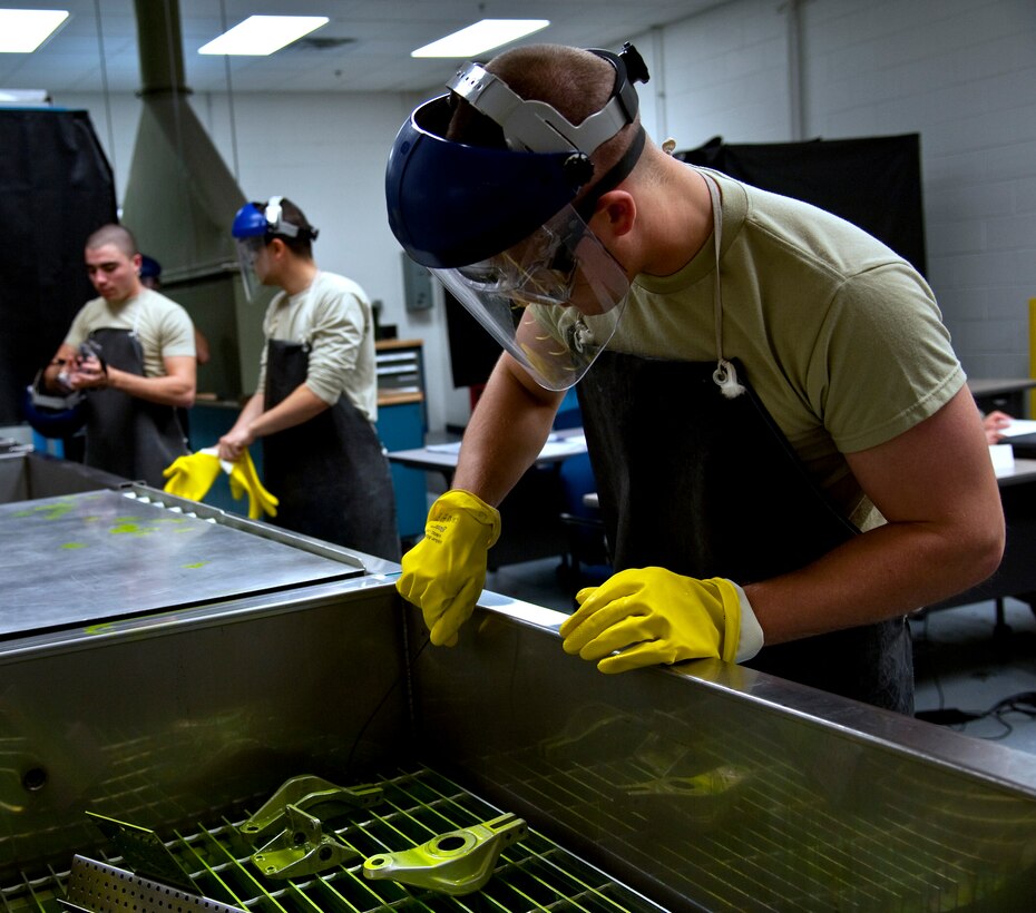 A Detachment 1, 359th Training Squadron nondestructive inspection student coats aircraft parts in liquid which detects corrosion at Naval Air Station Pensacola, Fla., Dec. 17, 2013. NDI Airmen also learn metal composition to understand how parts wear. (U.S. Air Force photo/Senior Airman Michelle Vickers) 