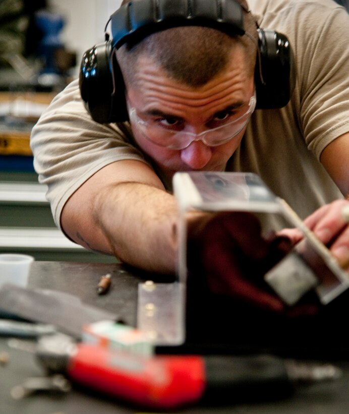 A Detachment 1, 359th Training Squadron aircraft structural maintenance student practices rivet repairs at Naval Air Station Pensacola, Fla., Dec. 17, 2013. ASM Airmen complete a variety of repairs to metal aircraft structures. (U.S. Air Force photo/Senior Airman Michelle Vickers)   