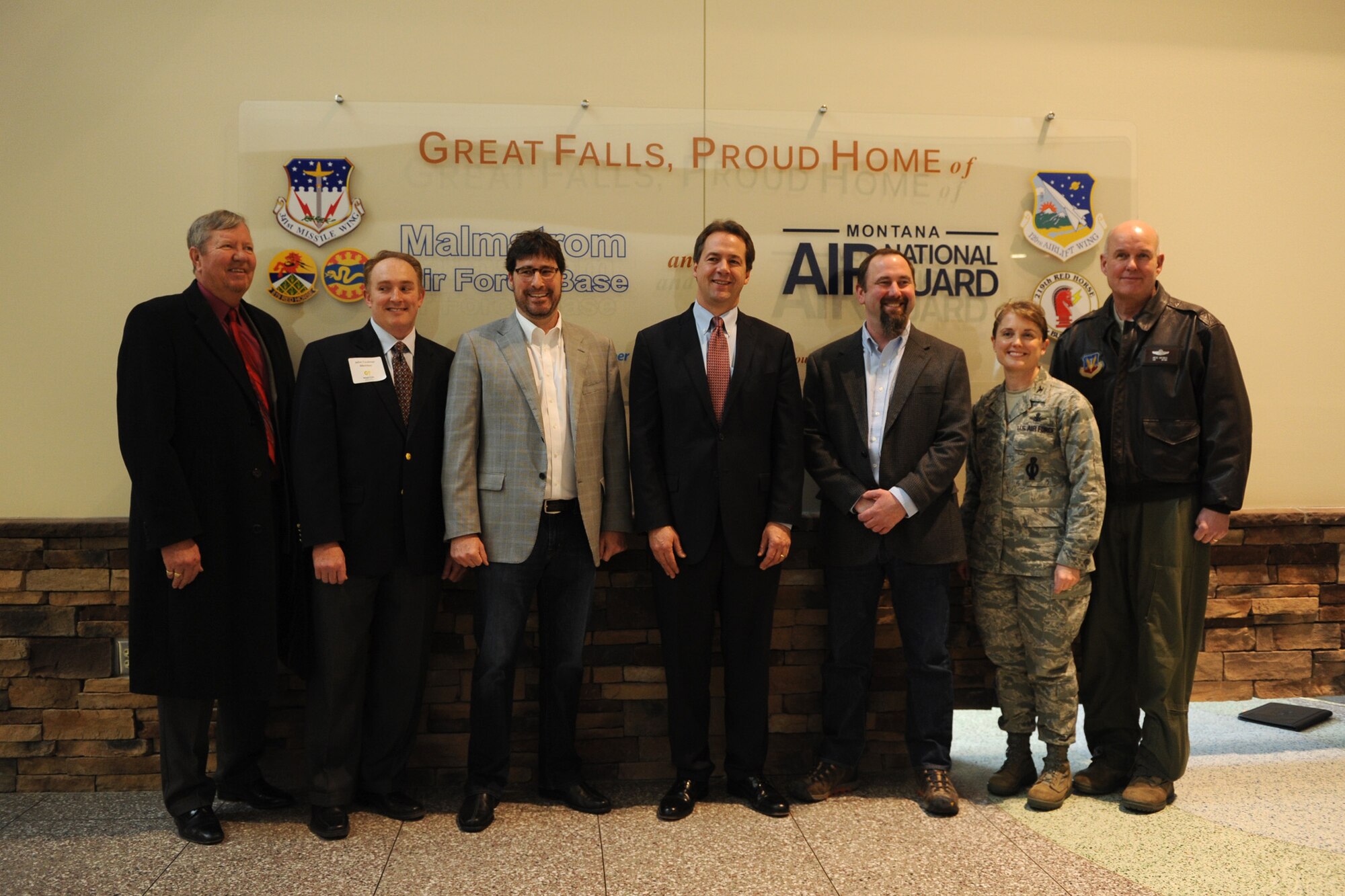 Various Montana leaders including the governor and Malmstrom Air Force Base and Montana Air National Guard members pose for a photo during a ribbon cutting ceremony at the Great Falls International Airport in Great Falls, Mont., on Jan. 8. Donated by the Montana Defense Alliance and the Military Affairs Committee of the Great Falls Area Chamber of Commerce, the new sign represents Malmstrom, MTANG and the 219th and 819th RED HORSE Squadrons. (U.S. Air Force photo/Senior Airman Katrina Heikkinen) 
