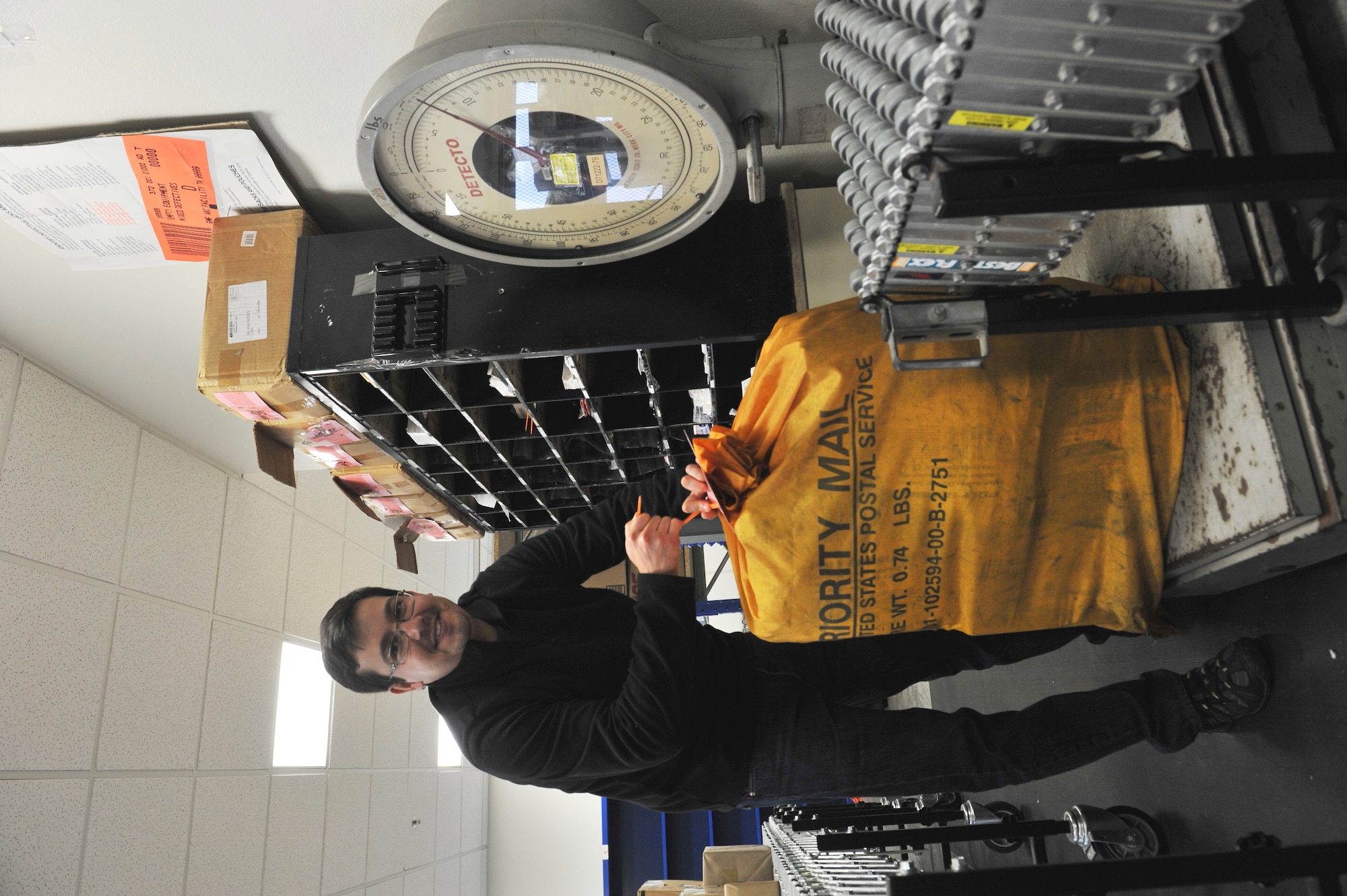 Portuguese employee Bruno Lima, 65th Communications Squadron postal clerk, bags and weighs outgoing mail at the Lajes Field Post Office Jan. 9, 2014. The 65th CS Postal Service team was recently awarded the Information Dominance Air Force Outstanding Small Postal Facility Award for 2013. (U.S. Air Force photo by Staff Sgt. Angelique N. Smythe)