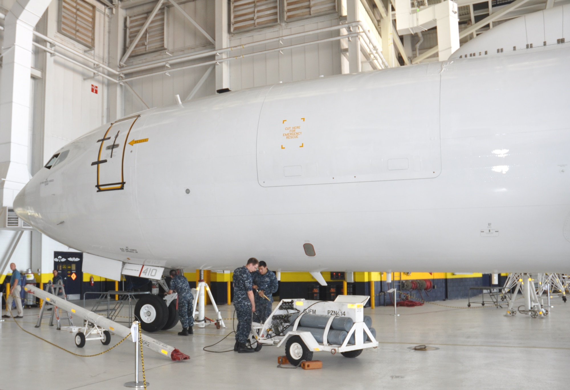 Navy personnel perform routine maintenance on an E-6B aircraft parked inside a TACAMO hangar at Tinker AFB. (Air Force photo by Mike W. Ray)
