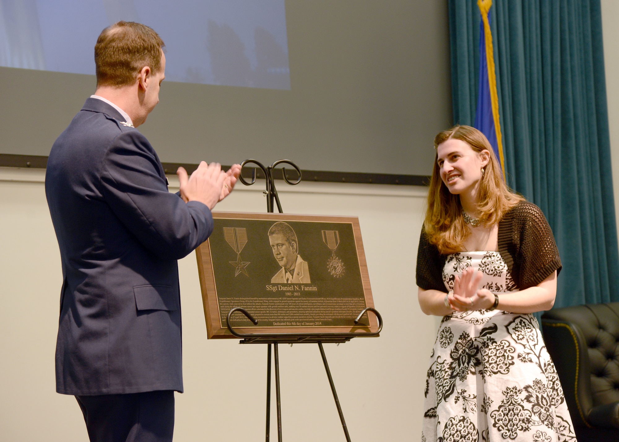 With the help of 552nd Air Control Wing commander Col. Jay Bickley, Sonja Fannin unveils a plaque honoring her late husband during a ceremony on Monday. Staff Sgt. Daniel Fannin, along with three other servicemen, died last April when the MC-12 Liberty plane in which they were flying a mission stalled and crashed near Kandahar Airfield, Afghanistan. The ceremony honored Sergeant Fannin, who was assigned to the 960th Airborne Air Control Squadron, by renaming the 552nd Operations Group Auditorium in Bldg. 282 as Fannin Hall. (Air Force photo by Kelly White)