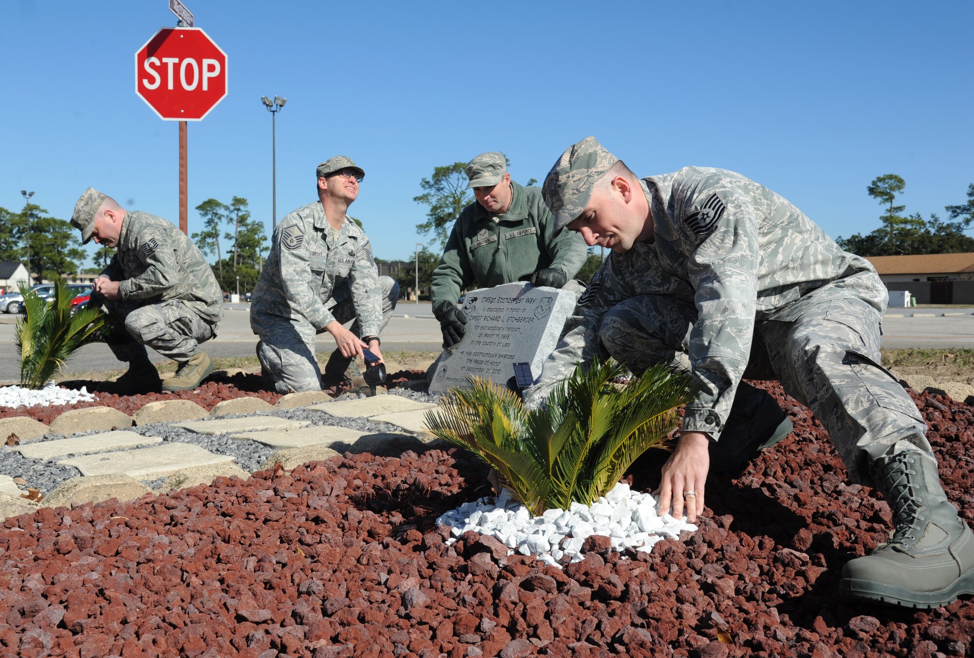 Tech. Sgt. Michael Farmer, Master Sgt. James Musgrove, Airman 1st Class Scott Brown and Tech. Sgt. Travis Smith, 338th Training Squadron, add final touches to the landscape area surrounding the Chief Master Sgt. Richard Etchberger monument, Jan. 8, 2014, located on the corner of Hangar Road and CMSgt. Etchberger Way at Keesler Air Force Base, Miss.  The monument and CMSgt. Etchberger way sign were unveiled during a street dedication ceremony that took place Sept. 16, 2013.   (U.S. Air Force photo by Kemberly Groue)