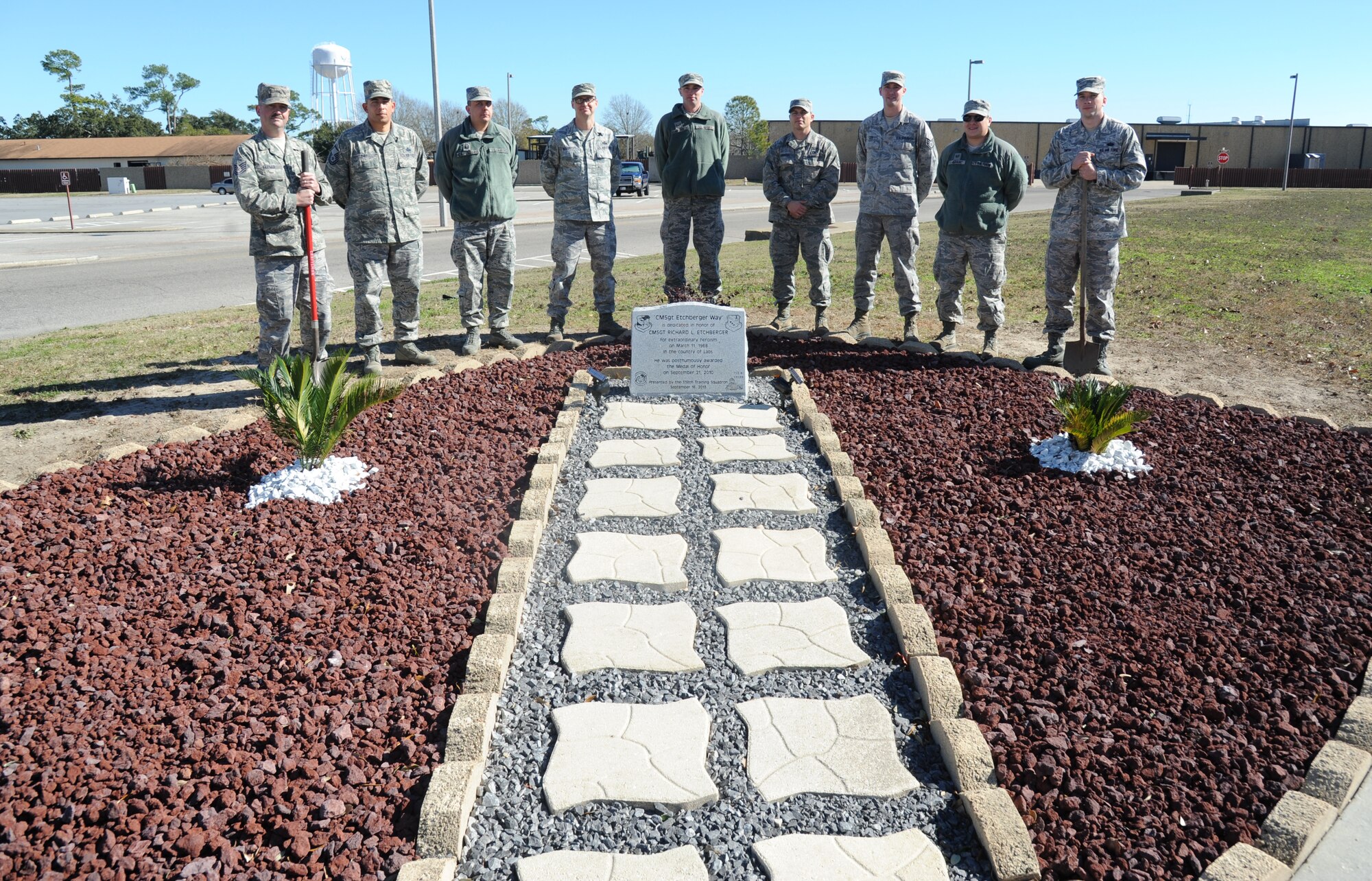 Tech. Sgt. Michael Farmer, Master Sgts. Juan Diaz, Thomas Capenegro and James Musgrove, Airman 1st Class Scott Brown, Staff Sgts. Dustin Haugh, Joshua Lee and Alexander Gould and Tech. Sgt. Travis Smith, 338th Training Squadron, stand behind the Chief Master Sgt. Richard Etchberger monument they designed Jan. 8, 2014, on the corner of Hangar Road and CMSgt. Etchberger Way.  The monument and CMSgt. Etchberger way sign were unveiled during a street dedication ceremony that took place Sept. 16, 2013. (U.S. Air Force photo by Kemberly Groue)