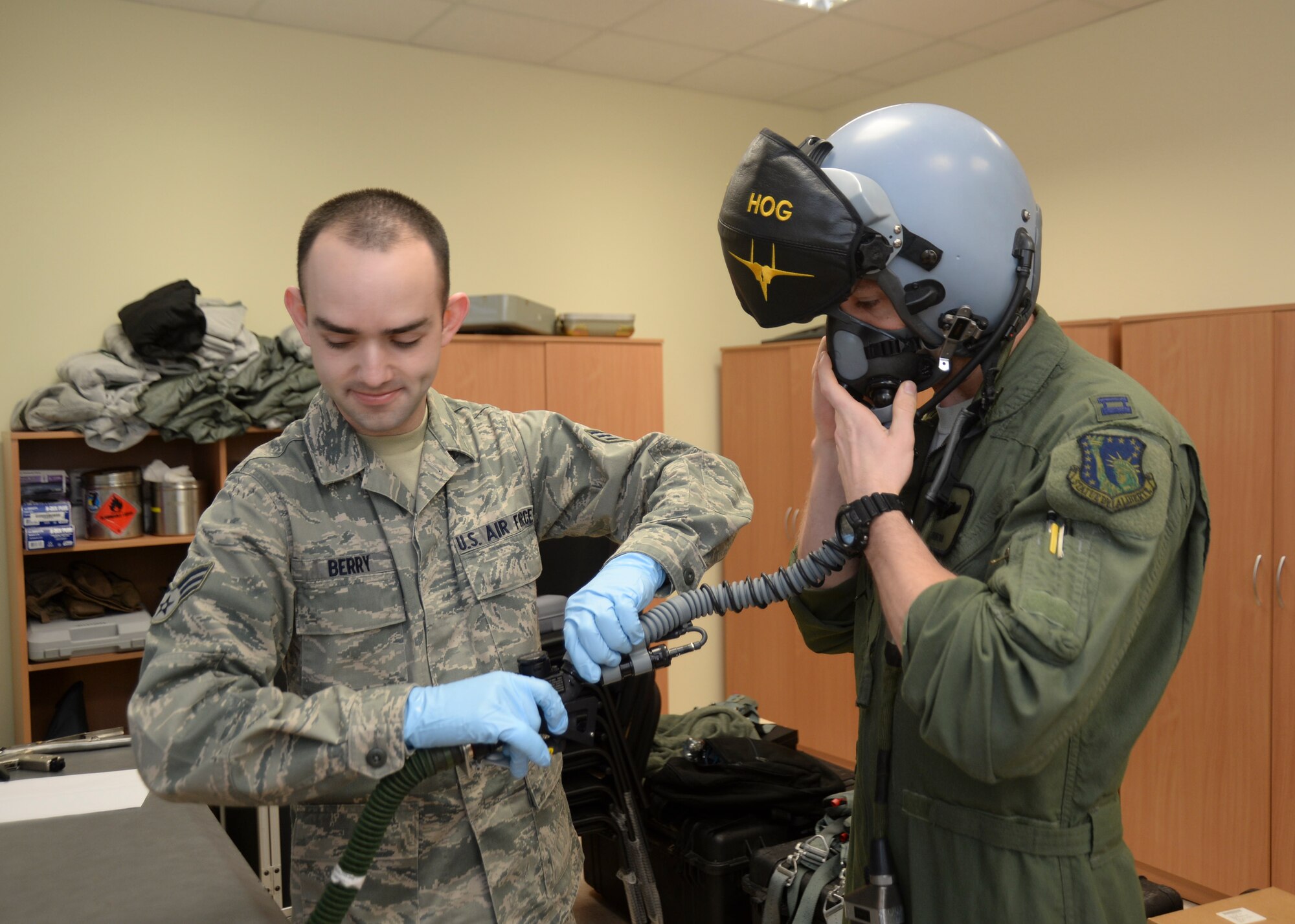 Senior Airman Jeffery Berry, 493rd Expeditionary Fighter Squadron aircrew flight equipment journeyman, fits Capt. Chris DuBois, 493rd Expeditionary Fighter Squadron pilot, with a helmet at the Quick Reaction Alert facility at Šiauliai Air Base, Lithuania, Jan. 7, 2014. Equipment is modified to fit each aircrew member properly, helping to prevent injury during ejection and minimizing distractions, allowing pilots to support the mission as safely as possible. (U.S. Air Force photo by Airman 1st Class Nigel Sandridge /Released)