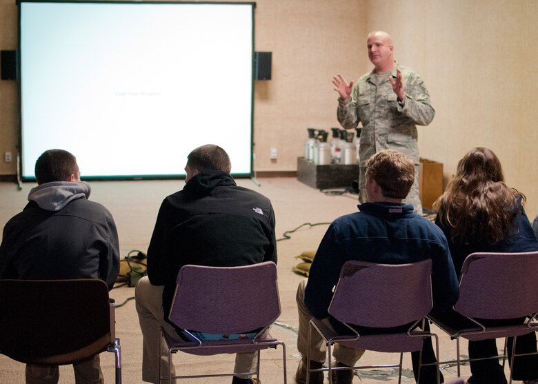 Master Sgt. Sean Dias, of the 102nd Security Forces Squadron talks with students from Sandwich Highschool on use-of-force techniques, laws, and concepts on Otis Air National Guard base, December 12, 2013. The students training was part of a law enforcement class and included the use of situation simulator which trains people how to react when faced with different law enforcement scenarios. (National Guard photo by Master Sgt. Aaron Smith/Released)