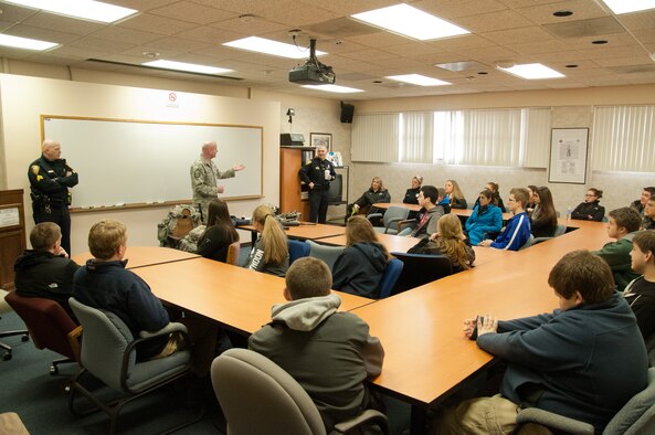 Master Sgt. Sean Dias, of the 102nd Security Forces Squadron, and Sandwich Police officers talk with students from Sandwich Highschool on use-of-force techniques, laws, and concepts on Otis Air National Guard base, December 12, 2013. The students training was part of a law enforcement class and included the use of situation simulator which trains people how to react when faced with different law enforcement scenarios. (National Guard photo by Master Sgt. Aaron Smith/Released)