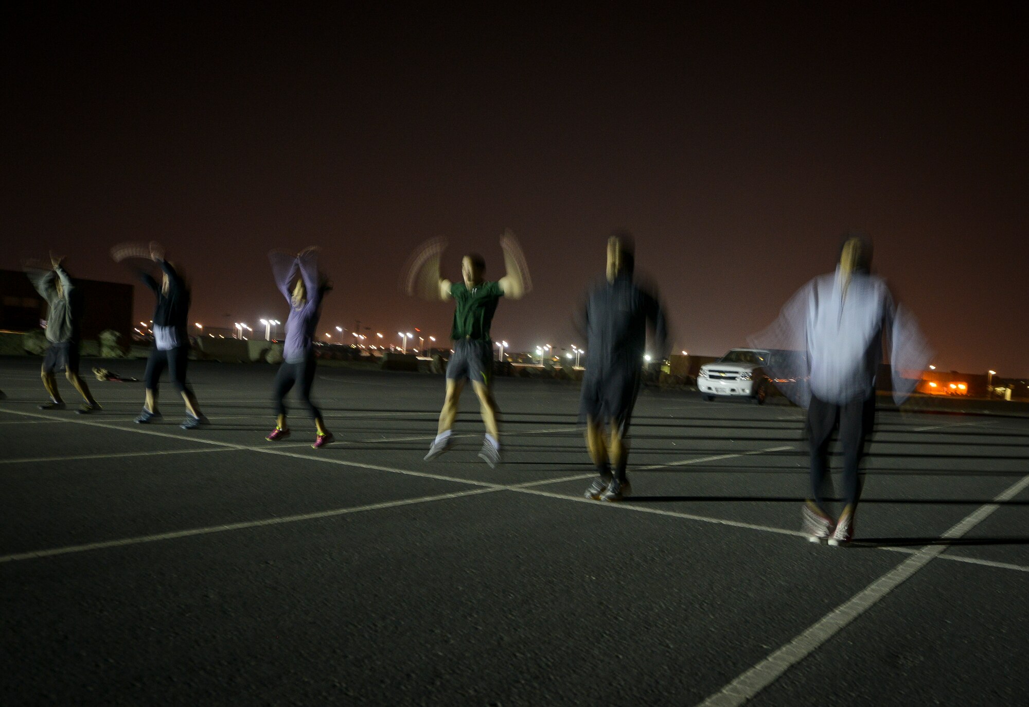 Participants of a Crossfit Undisclosed workout  peform jumping jacks Jan. 8, 2014 at Al Udeid Air Base Qatar. Crossfit Undisclosed, which was started in May 2013, hosts four classes a day and provides service members stationed here an alternative to a mundane workout routine.  (U.S. Air Force photo/Senior Airman Jared Trimarchi)