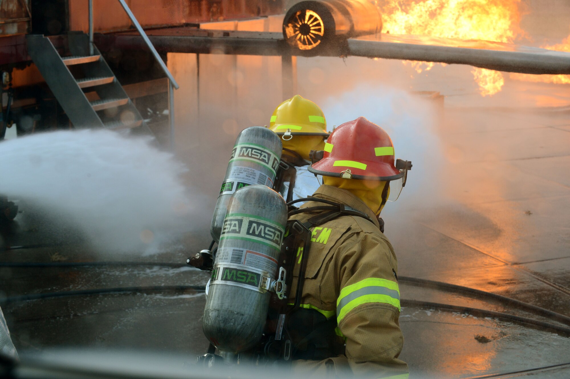 SPANGDAHLEM AIR BASE, Germany – U.S. Air Force firefighters suppress fires during a training exercise Jan. 8, 2014. During this training, fires reach upward of 500 degrees Fahrenheit inside a mobile aircraft fire trainer. (U.S. Air Force photo by Airman 1st Class Kyle Gese/Released)