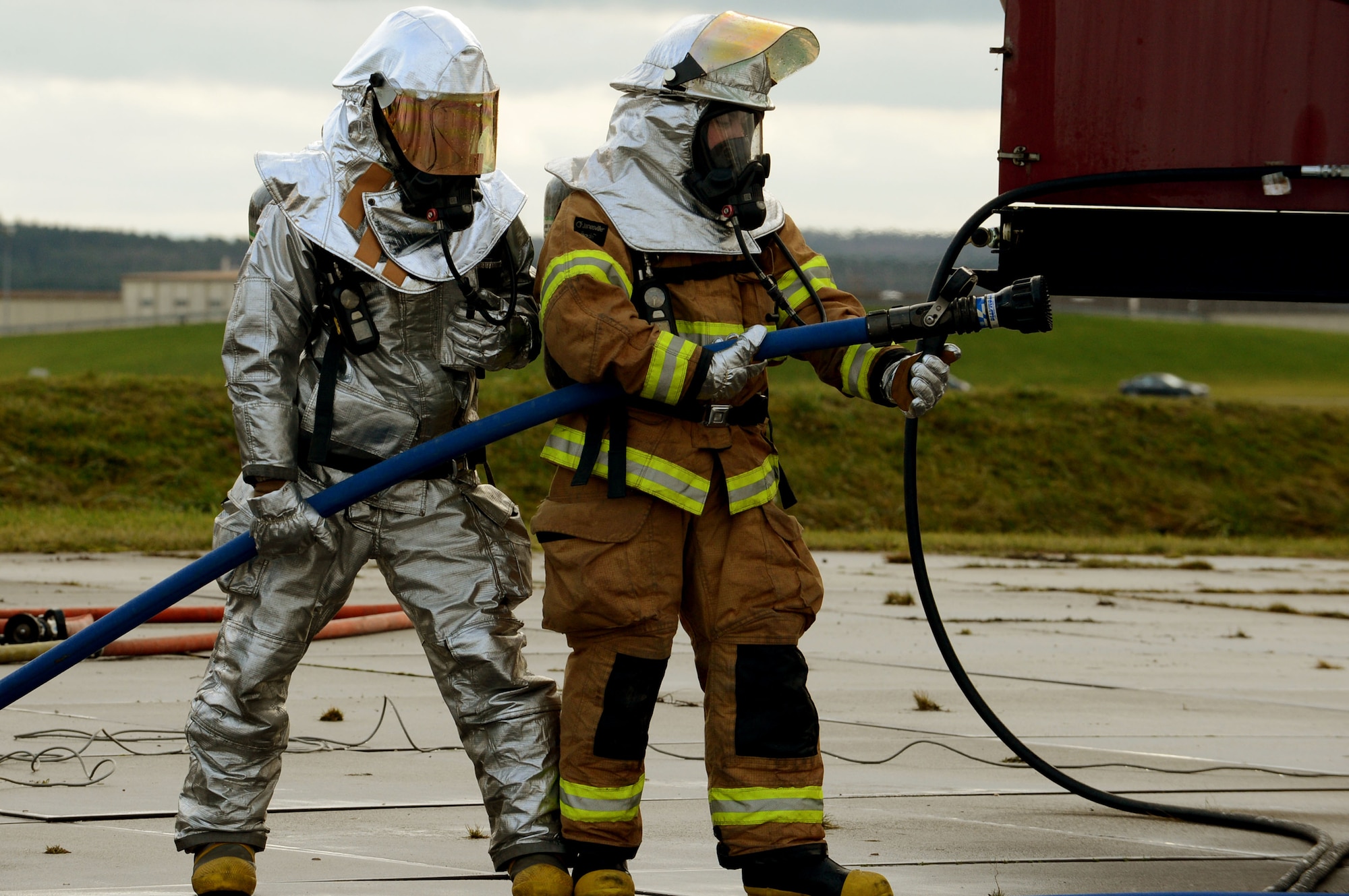 SPANGDAHLEM AIR BASE, Germany – U.S. Air Force firefighters prepare to extinguish flames during a live-fire training exercise on the burn pad Jan. 8, 2014. The fire department uses a mobile aircraft fire trainer to simulate a burning aircraft. This is an annual requirement for Spangdahlem to remain qualified in fire protection. (U.S. Air Force photo by Airman 1st Class Kyle Gese/Released)