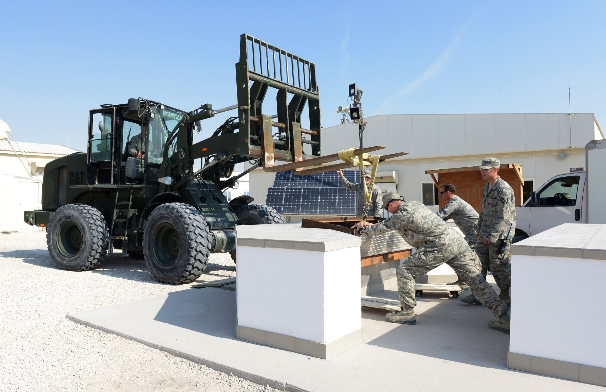 Airmen deployed to Al Udeid Air Base, Qatar, move the renovated grill into place Jan. 9, 2014, at Memorial Plaza. The 2013 Legacy Project project began on Dec 25, 2013, and was completed in five days total time. The Top Three is a professional organization that fosters the AUAB community through the interaction and camaraderie of its members.  The group promotes morale, esprit de corps and professional development, through volunteer opportunities, award programs, professional development seminars and encourage Airmen to take ownership and leave AUAB better then they found it. (U.S. Air Force photo/Senior Airman Hannah Landeros)
