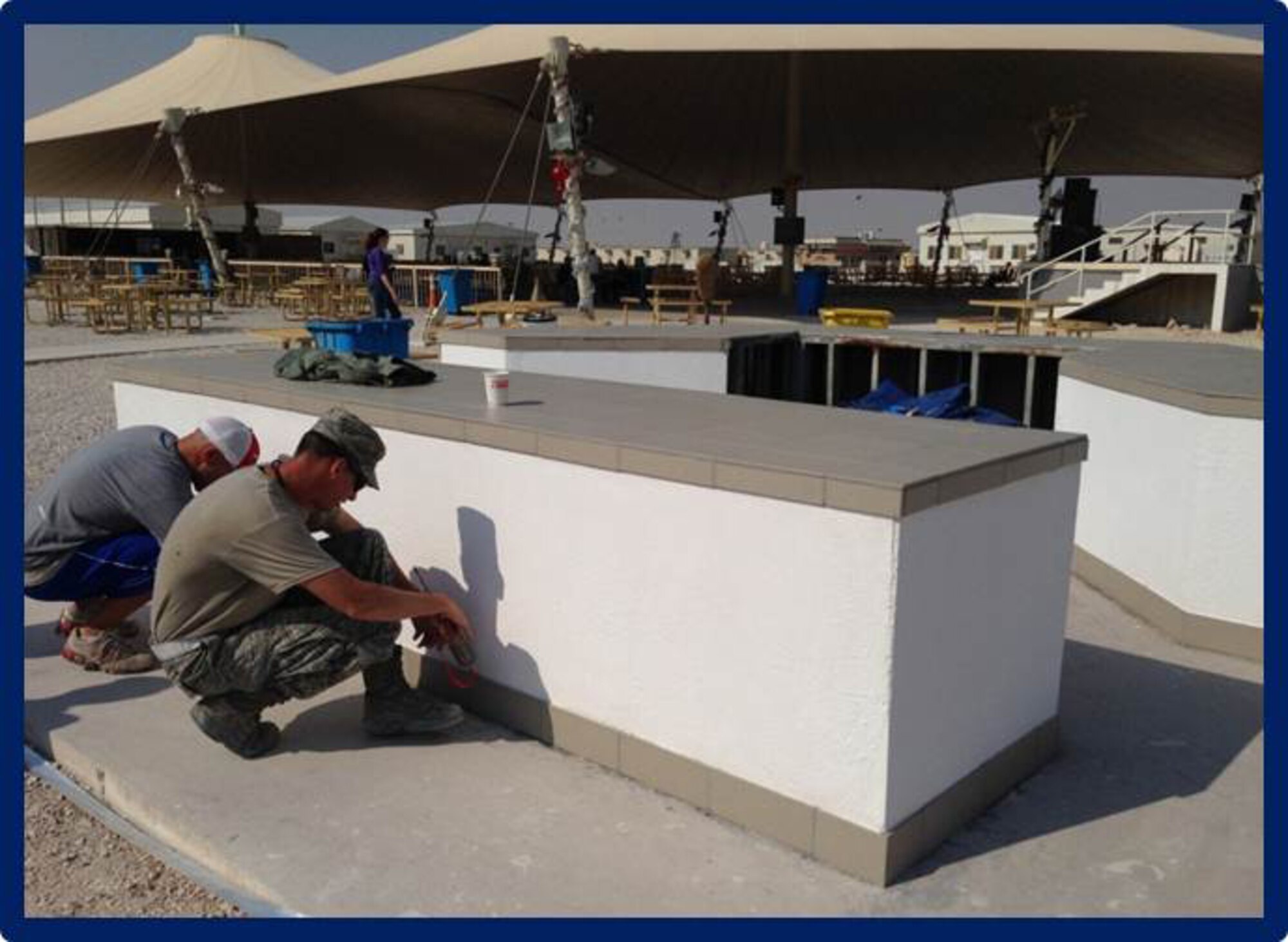 Master Sgt. Jason Gagnon and Master Sgt. Kevin Taylor, members of the Top Three, paint during the 2013 Legacy Project renovation at Memorial Plaza at Al Udeid Air Base, Qatar, Dec. 28, 2013. Gagnon was the project co-lead assigned to the 379th Expeditionary Communications Squadron, deployed from the U.S. Air Force Academy, Colo., and a Medway, Maine, native. Taylor is assigned to the 379th Expeditionary Maintenance Squadron, deployed from Seymour Johnson Air Force Base, N.C., and a Rockwell, Texas, native. The Top Three is a professional organization that fosters the AUAB community through the interaction and camaraderie of its members.  The group promotes morale, esprit de corps and professional development, through volunteer opportunities, award programs, professional development seminars and encourage Airmen to take ownership and leave AUAB better then they found it. (U.S. Air Force photo/ Tech. Sgt. Damian Davies)