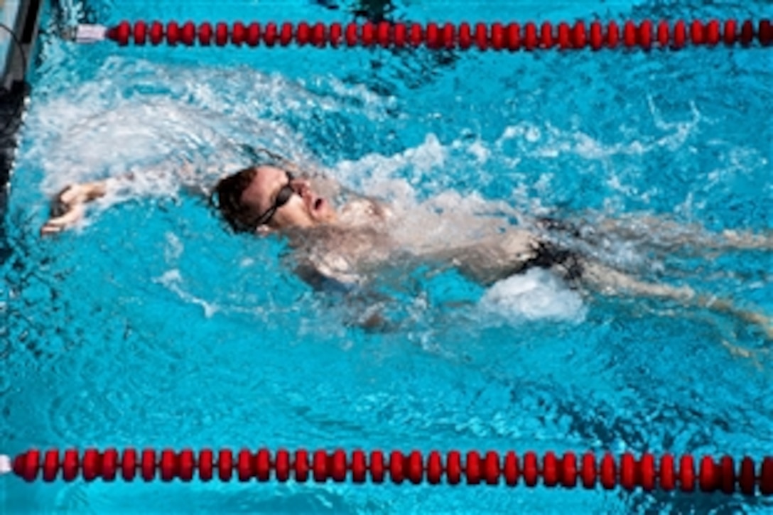 Retired Navy Petty Officer 2nd Class Patrick Blair finishes in first place for the men's 50-meter backstroke heat during the Wounded Warrior Pacific Invitational swim meet in Honolulu, Jan. 9, 2014. The meet is a competition among seriously wounded and ill service members from the Air Force, Army, Coast Guard, Navy and Special Operations Command. Blair was a logistics specialist.