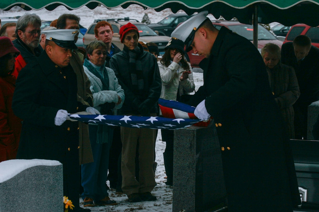 Staff Sgt. Nick K. Xayasene and Sgt. Ryan H, Magana, assigned to Company F, 2nd Battalion, 25th Marine Regiment, fold an American flag during the funeral of Staff Sgt. Michael B. Selavka, Jan. 10, at New Willimantic Cemetery.  The flag was later presented to Selavka’s brother, Jack, as part of the ceremony.  (U.S. Marine Corps photo by Lance Cpl. Brandon Thomas).