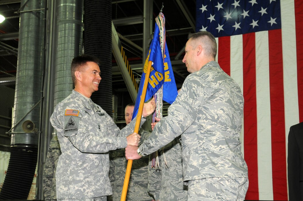 Maj. Gen. Jefferson S. Burton hands off the guide-on to Col. Darwin L. Craig during a change of command ceremony January 11, 2014.  Craig took command of the 151st Air Refueling Wing, replacing Col. Samuel H. Ramsay III after three and a half years as Wing Commander. (Utah Air National Guard photo by SSgt. Amber Monio/RELEASED)