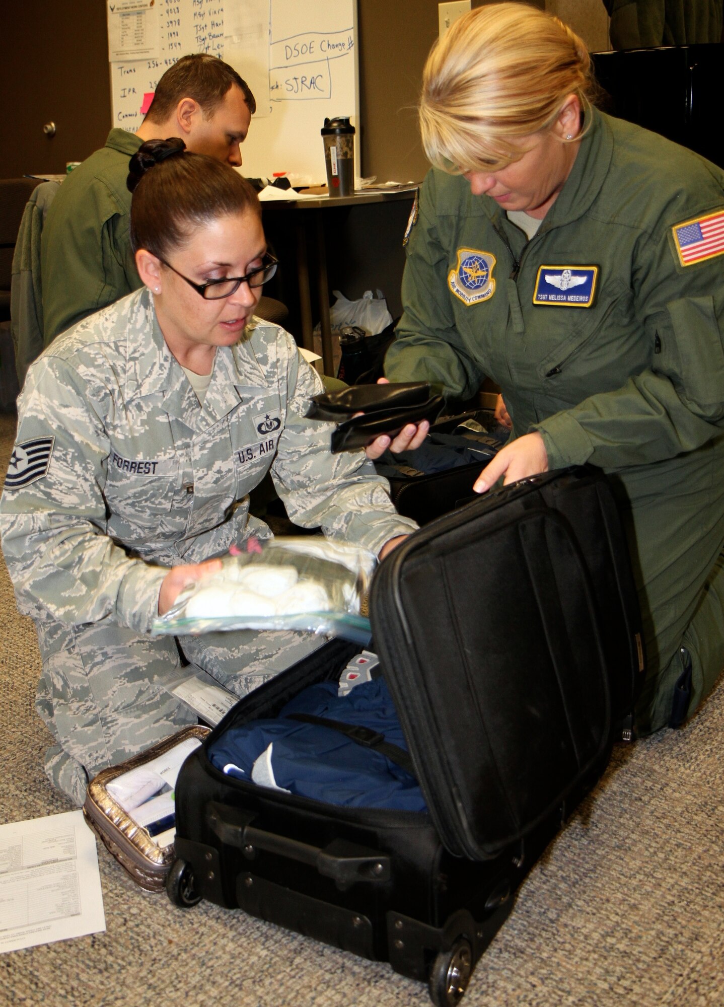 Tech. Sgt. Michelle Forrest, a 932nd Airlift Wing (AW) Unit Deployment Monitor, inspects Tech. Sgt. Melissa Medeiros' personal bag for required items during a deployment exercise, Jan. 11, at Scott Air Force Base (AFB). Personnel from Scott AFB's 932nd AW and the active duty 375th Air Mobility Wing worked together during the 4-day exercise to prepare for future mass deployments. (U.S. Air Force photo / Tech. Sgt. Christopher Parr)