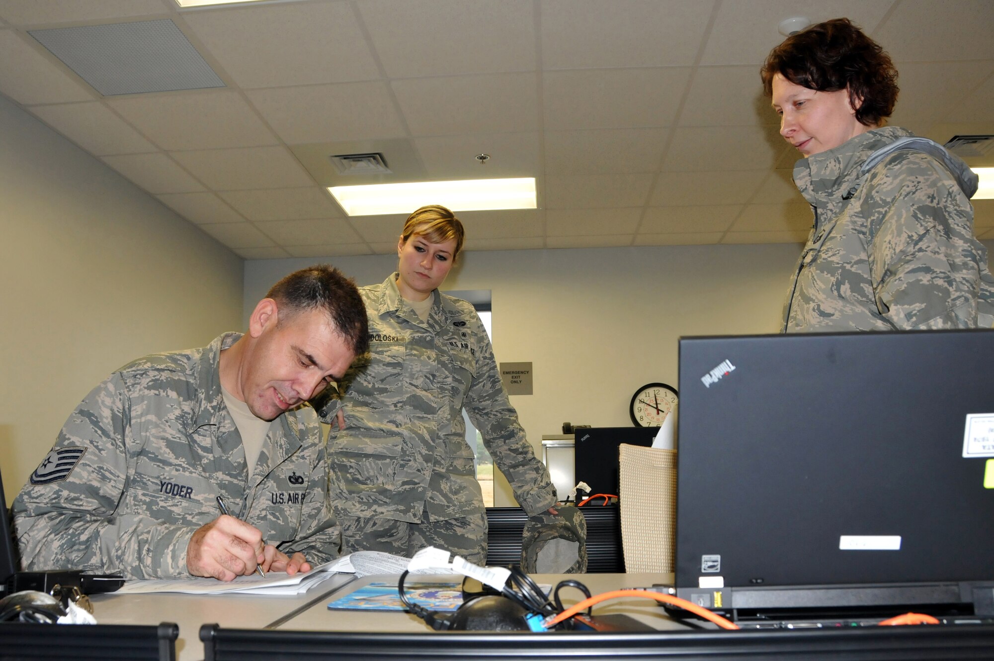 Tech. Sgt. William Yoder, 512th Security Forces Squadron member and travel voucher subject matter expert, walks Senior Airman Elizabeth Wendoloski (left) and Master Sgt. Jennifer Royer, 512th Legal Office, through the proper way to file their travel voucher at a travel voucher lab, Dover Air Force Base, Del., Jan. 11, 2014. The travel voucher lab was created in an effort to assist 512th Airlift Wing members receive their travel pay faster and ensure timely government travel card payments. (U.S. Air Force photo/Staff Sgt. Cole Presley)