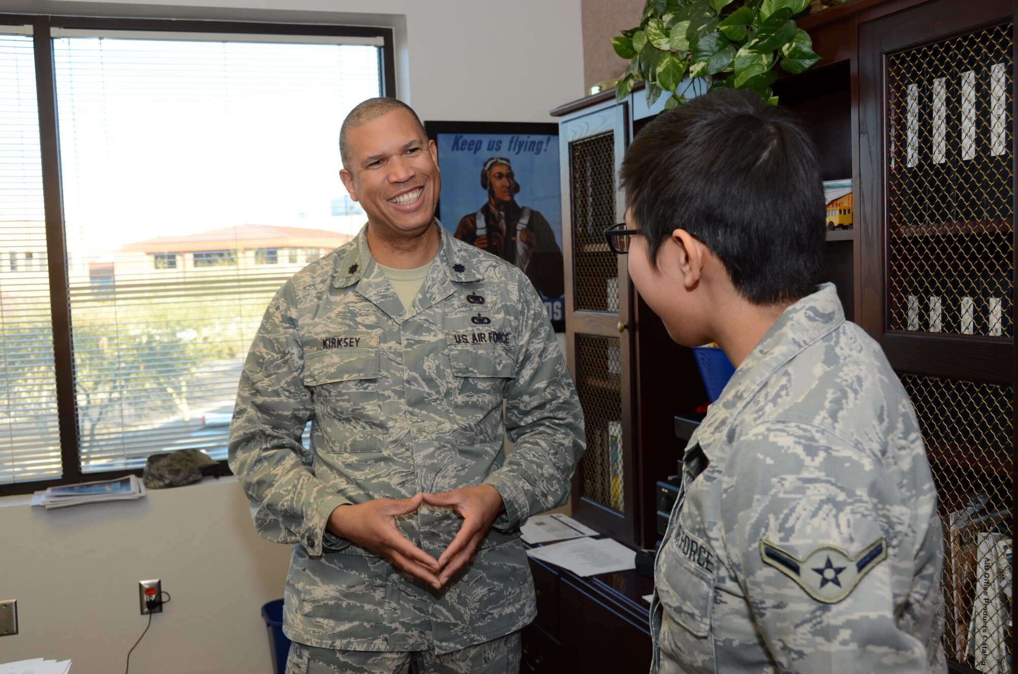 U.S. Air Force Lt. Col Allen Kirksey, 161st Air Refueling Wing chief of staff, mentors Airman Treva Begay, 161st Air Refueling Wing, knowledge operator, on the importance of being a leader and making the most of opportunities.  Colonel Kirksey is the 2014 Calvin C. Goode Lifetime Achievement award recipient for his exceptional commitment to the community. (Air National Guard photo by Senior Airman Rashaunda Williams)