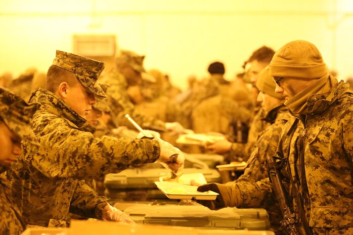 Marine food service specialist students from Fort Lee, Va., serve a hot breakfast to students from The Basic School at Military Operations on Urban Terrain Town aboard Marine Corps Base Quantico on Jan. 10, 2014. Last fiscal year a reorganization of Formal Learning Centers within Training Command realigned MCD Fort Lee under Weapons Training Battalion, Quantico.