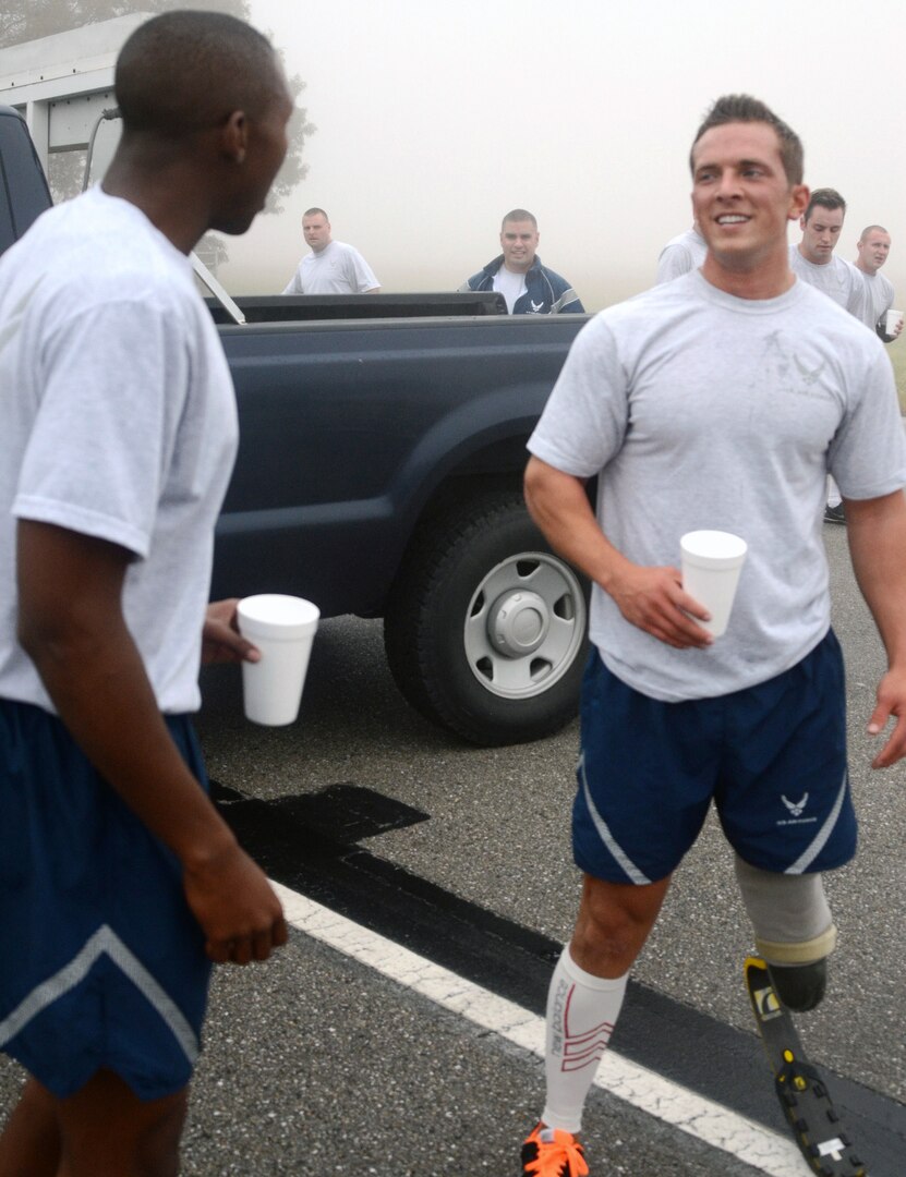 After a fast time in the 1.5 mile run, Senior Airman Gideon Connelly, right, relaxes with a drink with SrA Daniel Gernerette, the first place finisher in 175th Maintenance Squadron annual PT test. Connelly has a prostetic left leg. He scored a 94.80 percent on the test by completing 71 sit ups and 90 push ups in addition to his run time of 11 minutes and 17 seconds.