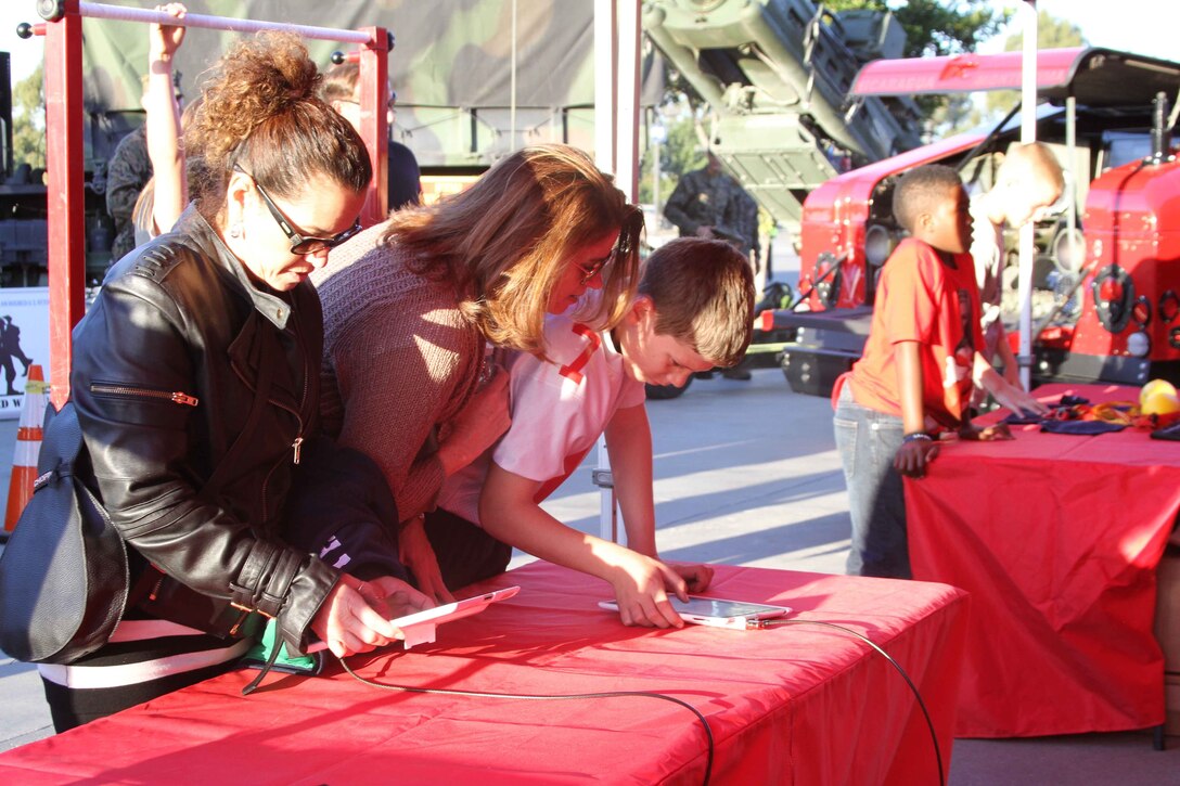 Semper Fidelis All-American Bowl attendees fill out iPads to do pull-ups for prizes during the fan fest before the Semper Fidelis All-American Bowl at The StubHub Center in Carson, Calif., Jan. 5, 2014. Local Marines from the reserve center and recruiting district set up vehicles and booths for the bowl attendees to learn more about the Marine Corps and be entertained before the start of the game. The Semper Fidelis Football Program brought together over 90 of the best high-school football players in an East versus West game and is an opportunity for the Marine Corps to connect on a personal and local level with players and influencers, demonstrates commitment to developing quality citizens, and reinforces how core values of honor, courage and commitment relate to success on and off the field. (Official U.S. Marine Corps photo by Sgt. Dwight A. Henderson/Released)