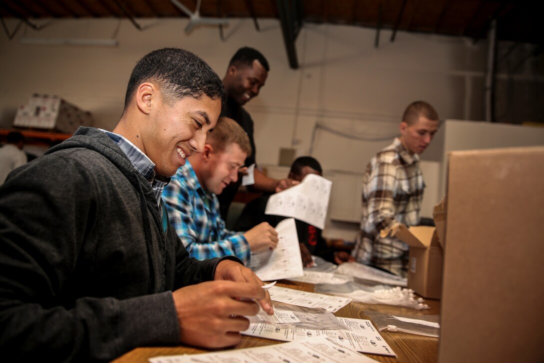 Corporal Richard Hernandez, data network specialist, 15th Marine Expeditionary Unit, prepares to package bags of oatmeal during a volunteer event at The Angel's Depot in Vista, Calif., Jan. 10, 2014. More than 10 Marines and sailors with the 15th MEU volunteered for the event. (U.S. Marine Corps photo by Cpl. Emmanuel Ramos/Released)