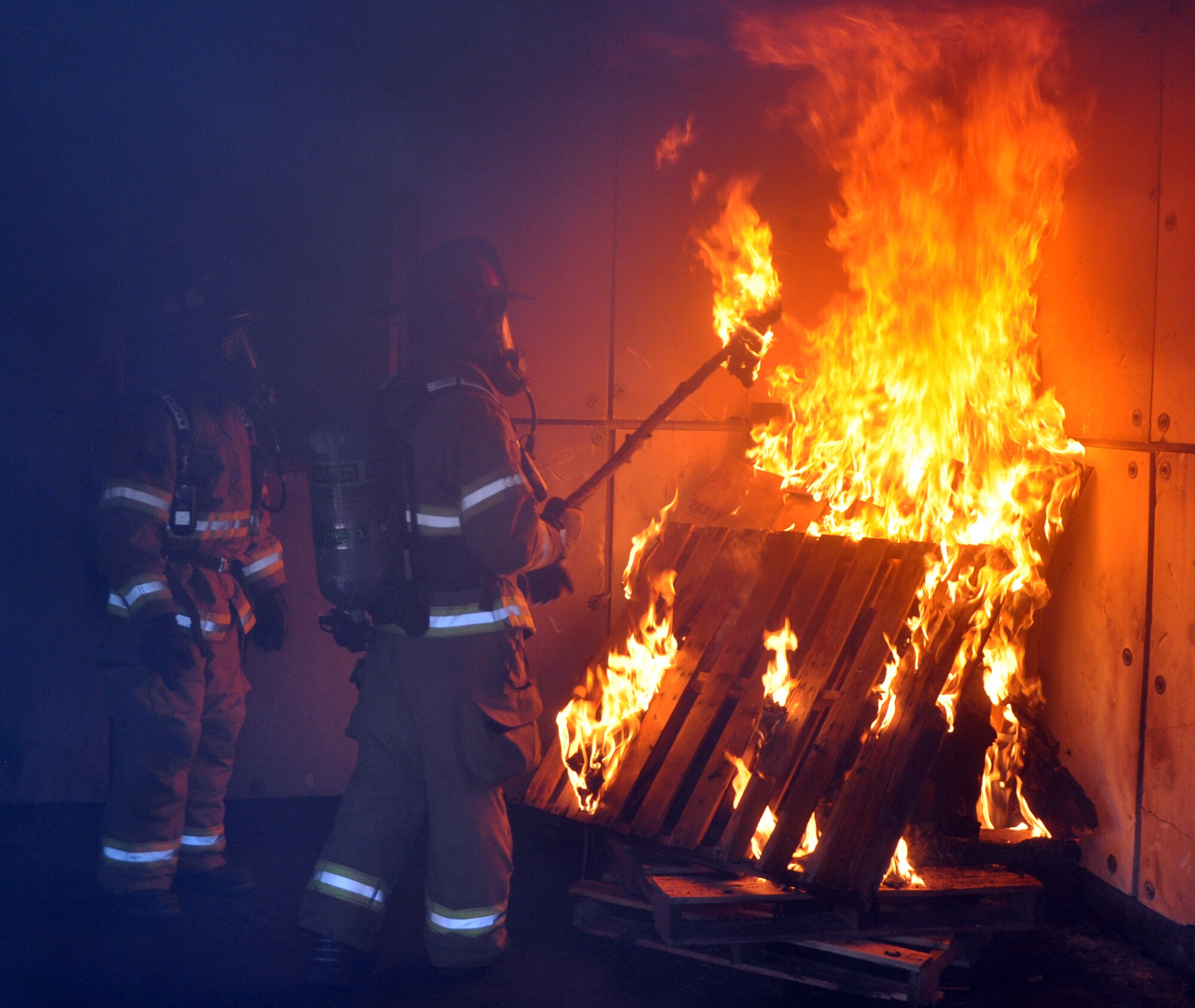 Firefighters from Joint Task Force-Bravo's 612th Air Base Squadron build a fire for a live burn exercise in the "burn house" at Soto Cano Air Base, Honduras, Jan. 13, 2014. U.S. Air Force Brig. Gen. Peter E. Gersten donned fire protective gear and joined the firefighters for the exercise, during which the firefighters were able to demonstrate for the General the tactics used to combat fires.  (U.S. Air Force photo by Capt. Zach Anderson)