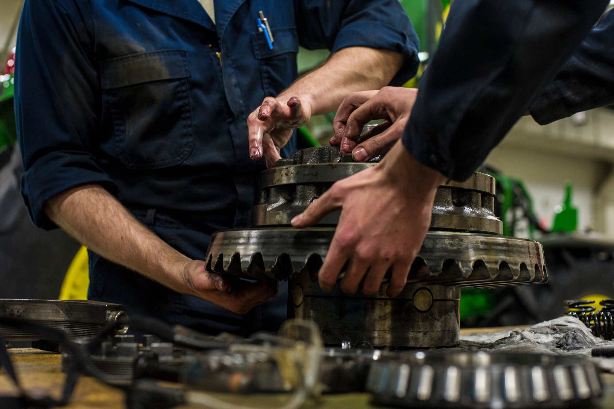 U.S. Air Force Senior Airman Anthony Tavares and Airman 1st Class Mitch Whitman, 354th Logistics Readiness Squadron vehicle maintenance flight, disassemble a differential from a flightline snow broom Jan. 9, 2014, Eielson Air Force Base, Alaska. The snow broom helps clear more than 100 miles of paved and unpaved roads during the winter season. (U.S. Air Force photo by Senior Airman Joshua Turner/Released)