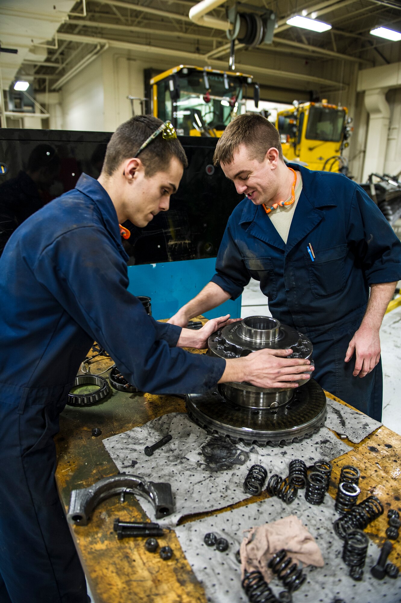 U.S. Air Force Senior Airman Anthony Tavares and Airman 1st Class Mitch Whitman, 354th Logistics Readiness Squadron vehicle maintenance flight, disassemble a differential from a flightline snow broom Jan. 9, 2014, Eielson Air Force Base, Alaska. The flightline snow broom removes snow from 1.9 million square-feet of airfield pavement annually. (U.S. Air Force photo by Senior Airman Joshua Turner/Released)