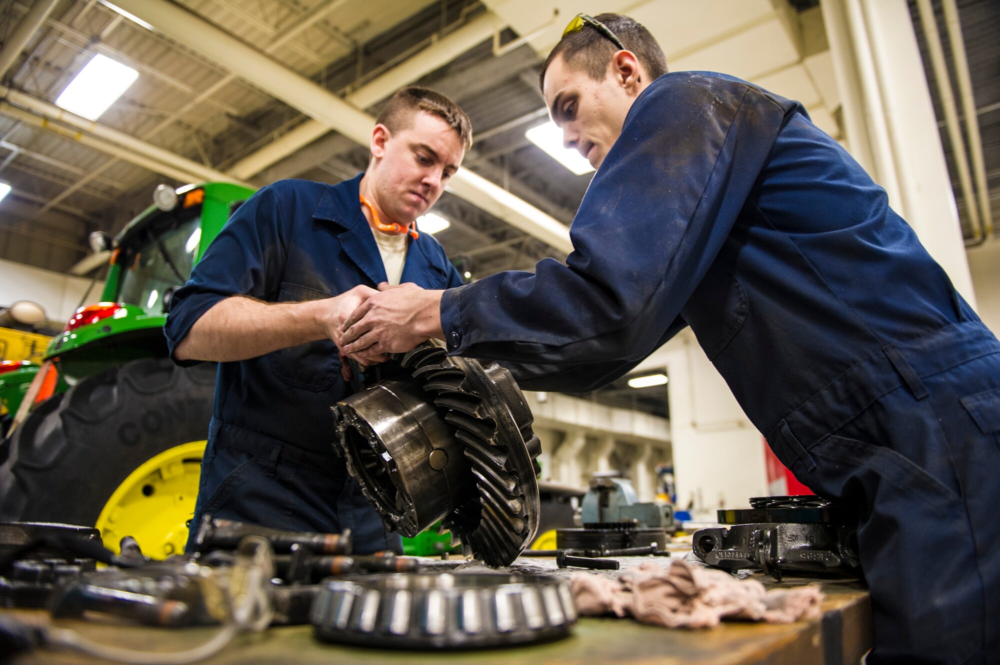 U.S. Air Force Senior Airman Anthony Tavares and Airman 1st Class Mitch Whitman, 354th Logistics Readiness Squadron vehicle maintenance flight, disassemble a differential from a flightline snow broom Jan. 9, 2014, Eielson Air Force Base, Alaskan. Keeping the flightline cleared is a 24-hour job during the Alaska winter, a job essential in maintaining flying operations. (U.S. Air Force photo by Senior Airman Joshua Turner/Released)